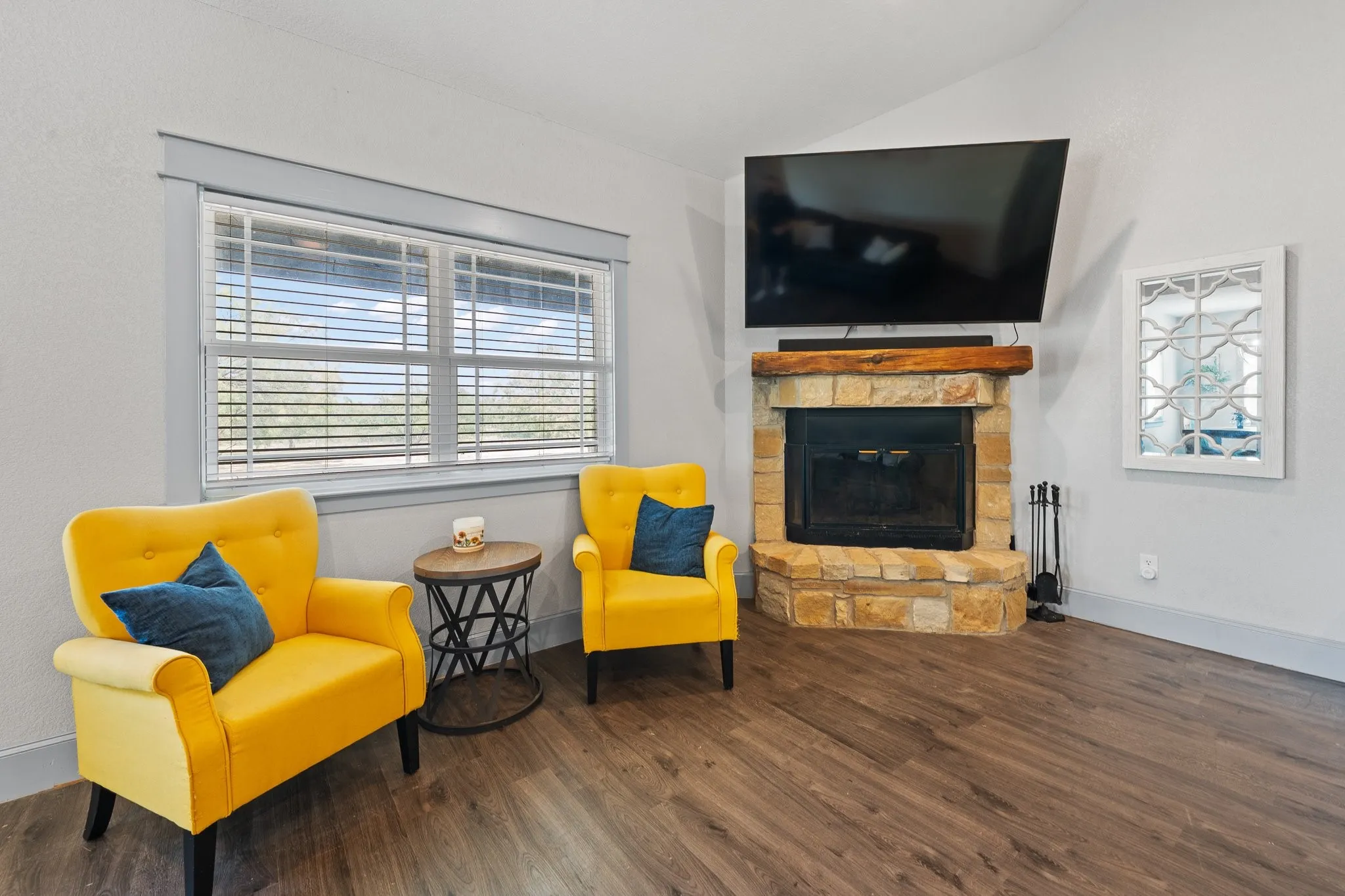 Corner fireplace featuring a stone surround and wood mantel