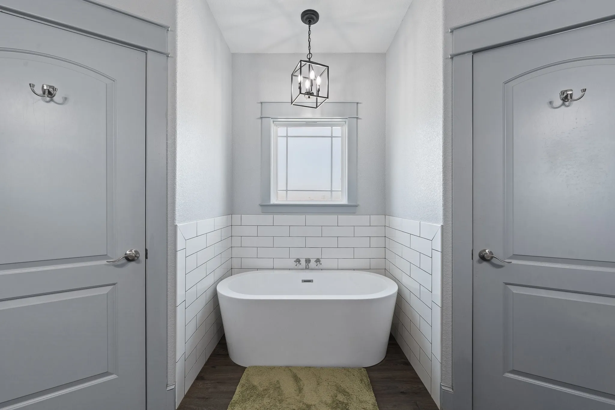 Freestanding soaking tub with wall-mounted fixtures