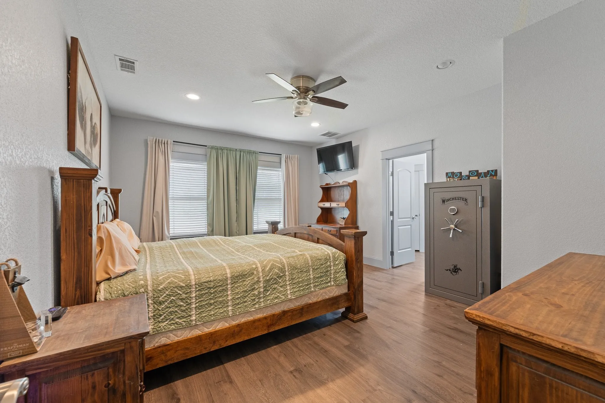 Spacious primary bedroom featuring wood-finish flooring, recessed lighting, and a ceiling fan