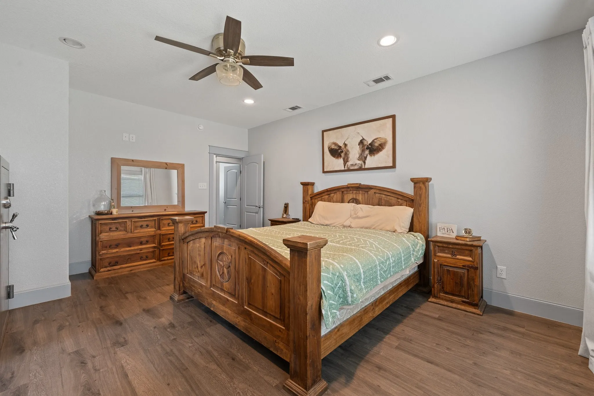 Spacious primary bedroom featuring wood-finish flooring, recessed lighting, and a ceiling fan