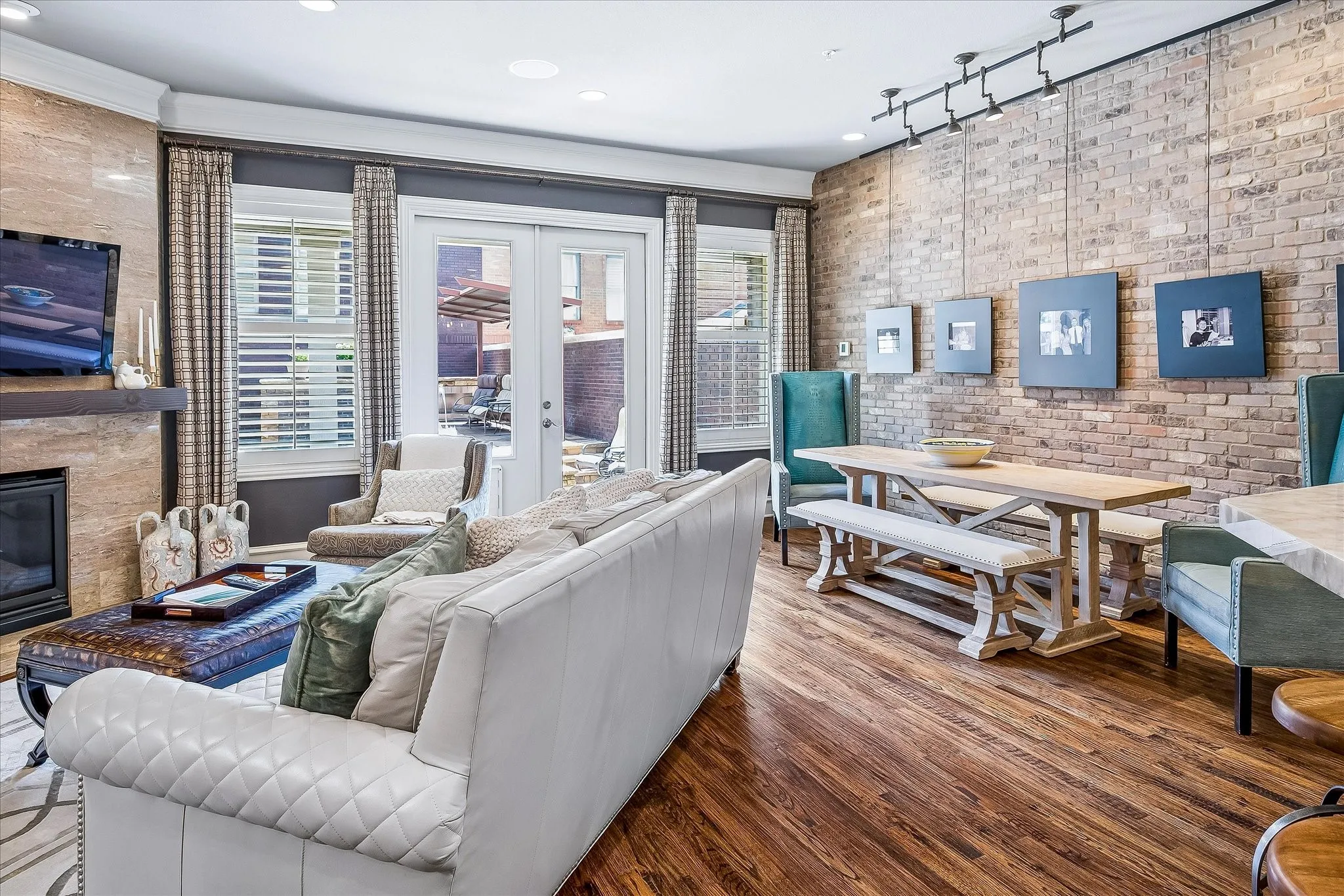 Main living area is open to the kitchen and breakfast area. Brick accent wall again adds so much character. Custom window treatments. Shutters throughout the home.