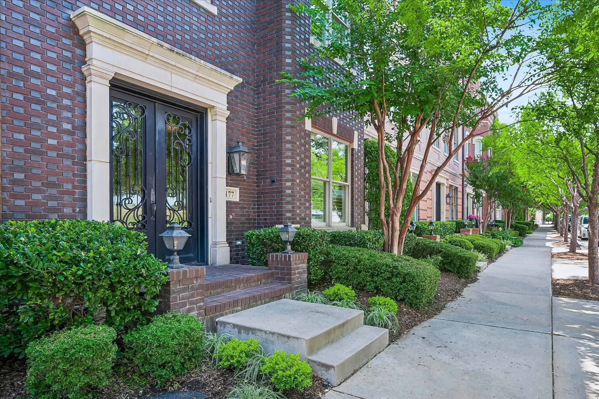 Tree lined streets in this Brownstone neighborhood.  Iron glass front door.