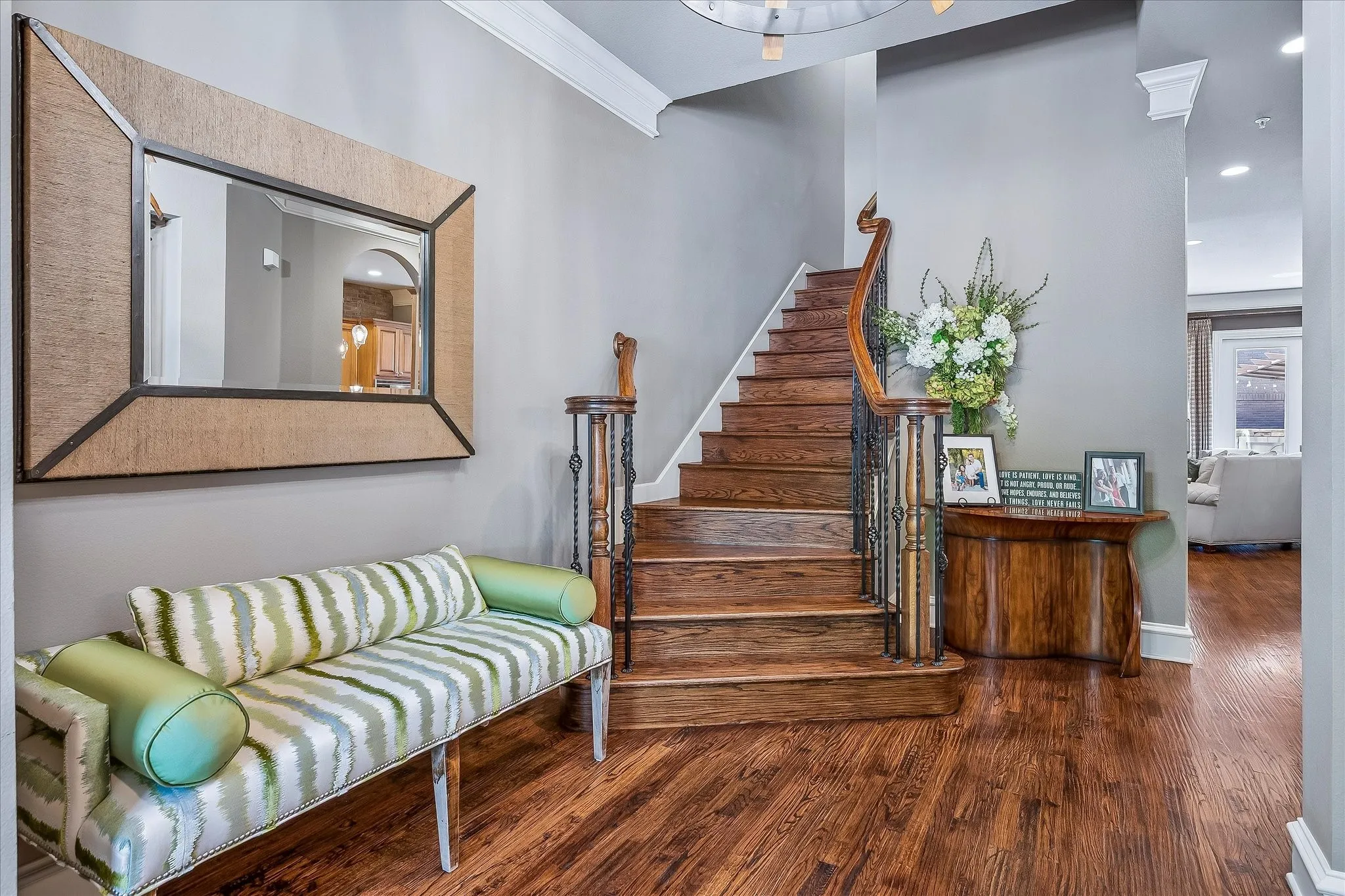 View from the front door, wood risers and stairs with wrought iron balusters to each floor.