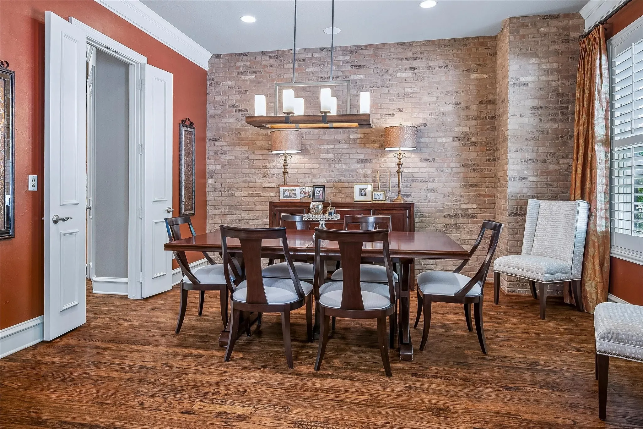 Dining area or could be a sitting room or another living area has custom brick accent wall, bay windows overlook the park across the street. Double doors go directly into the kitchen.
