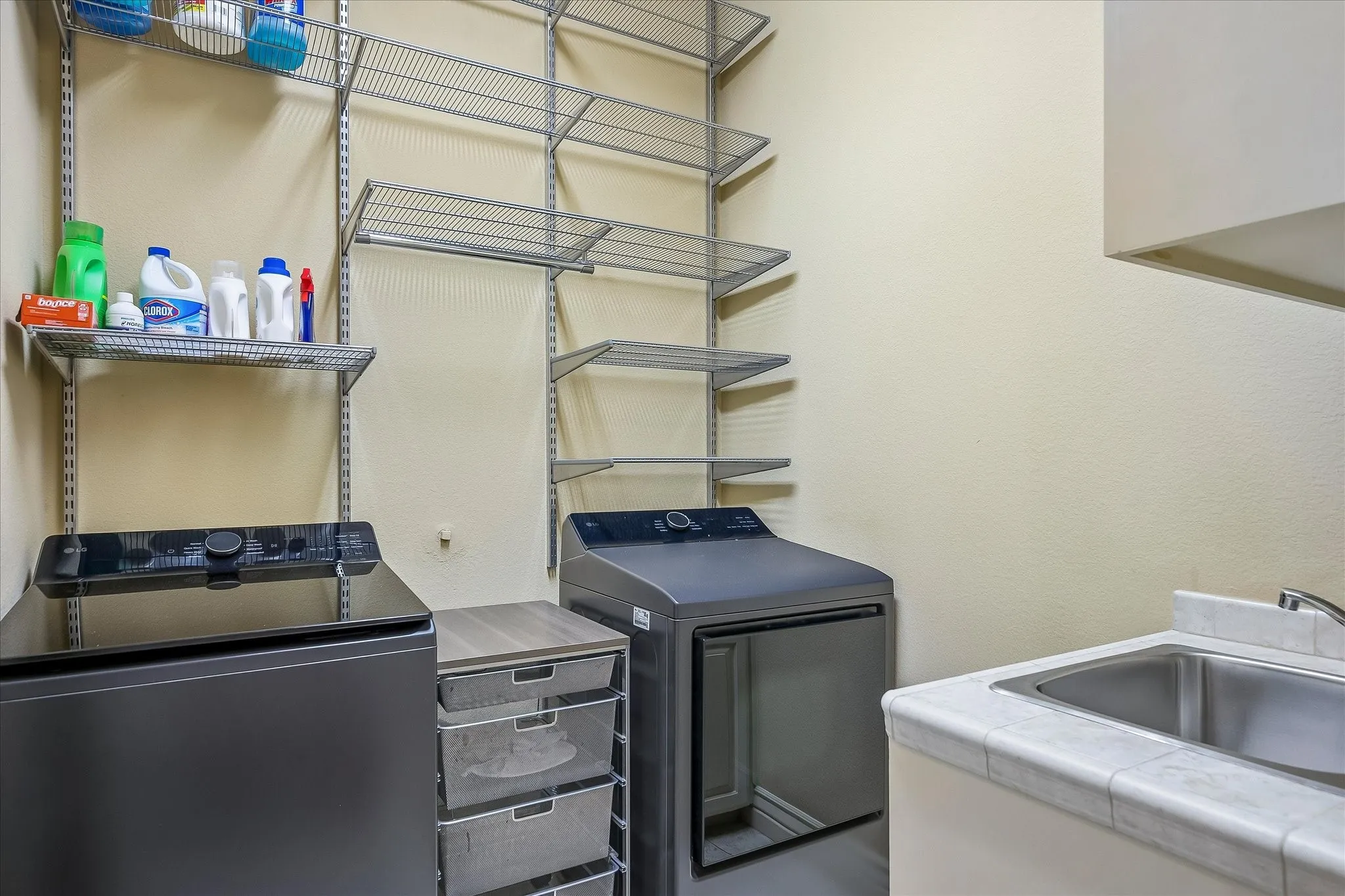 Laundry room near the primary bedroom. Elfa shelving, sink, built in cabinets.