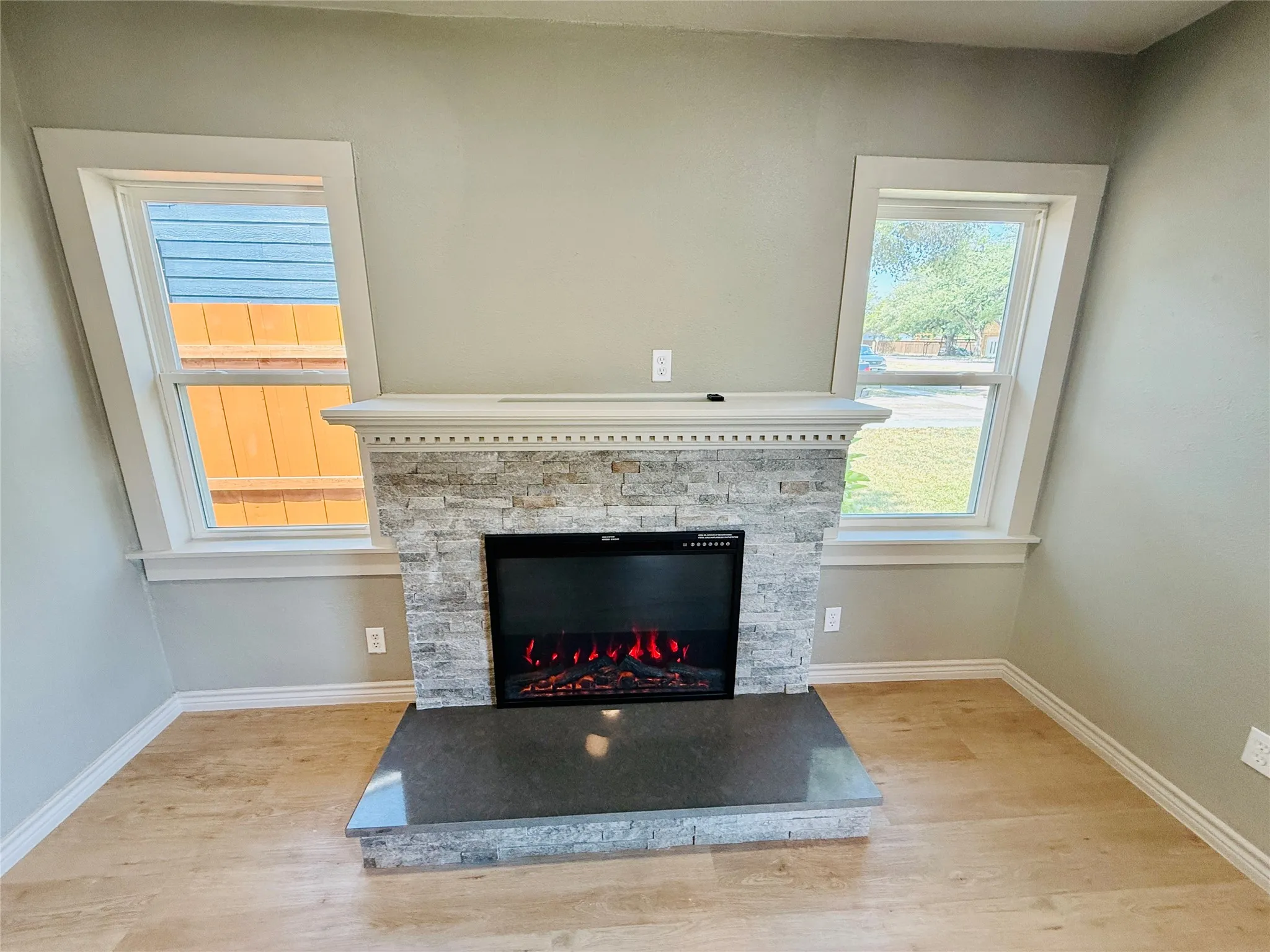 Fireplace with stone surround and mantle, featuring a dark hearth