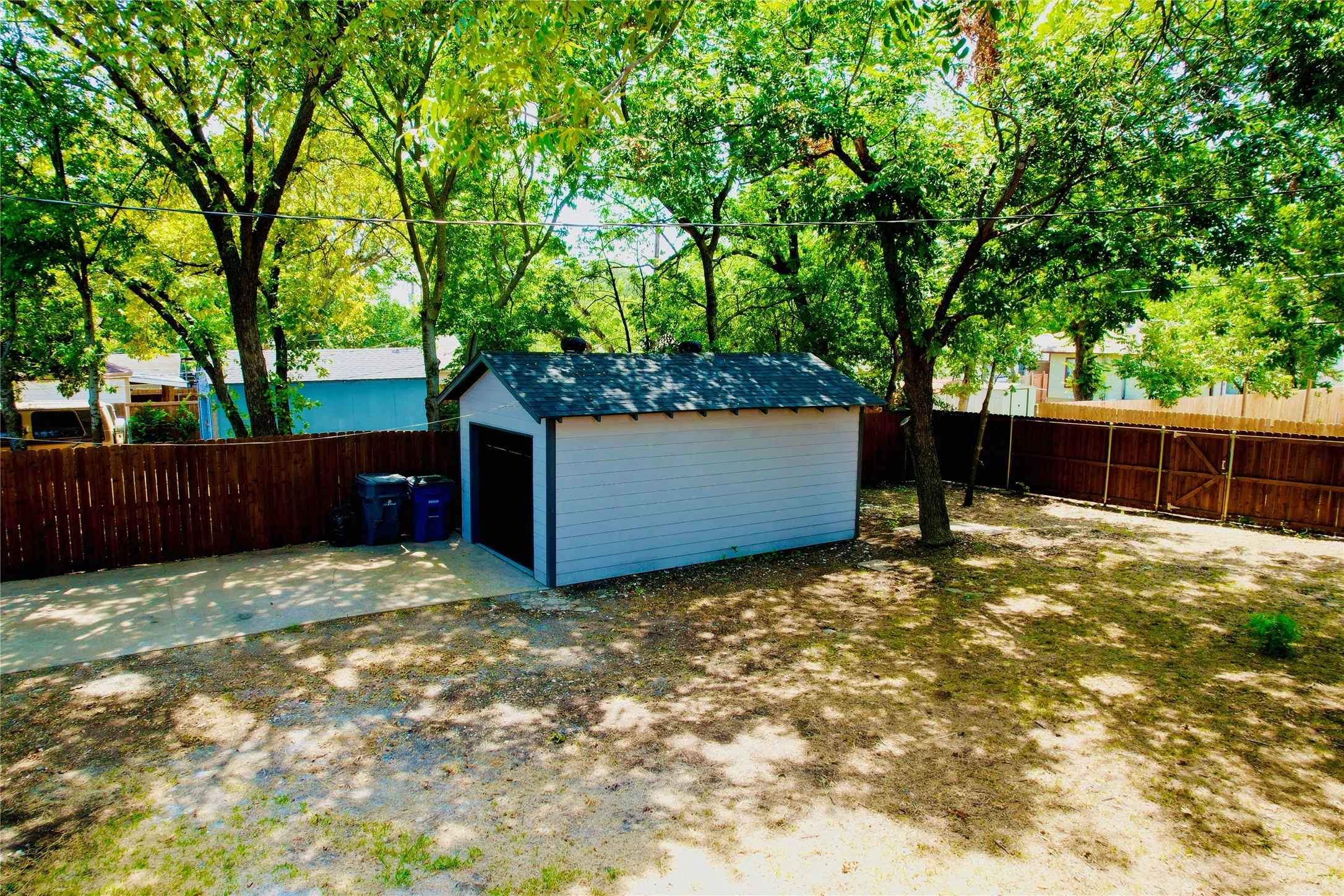 Detached storage shed featuring horizontal siding and an asphalt shingle roof