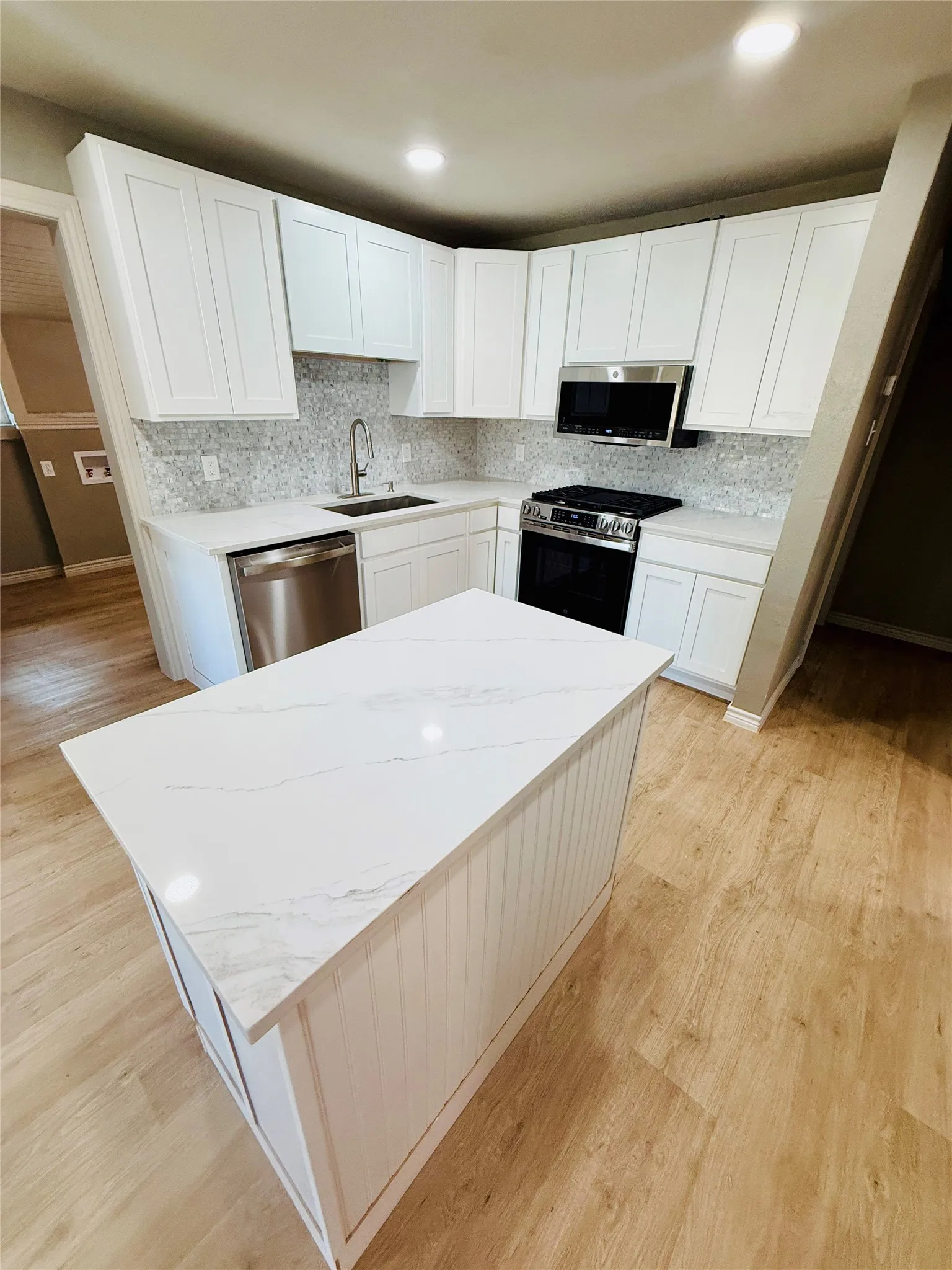 Kitchen featuring a central island with a stone-finish countertop