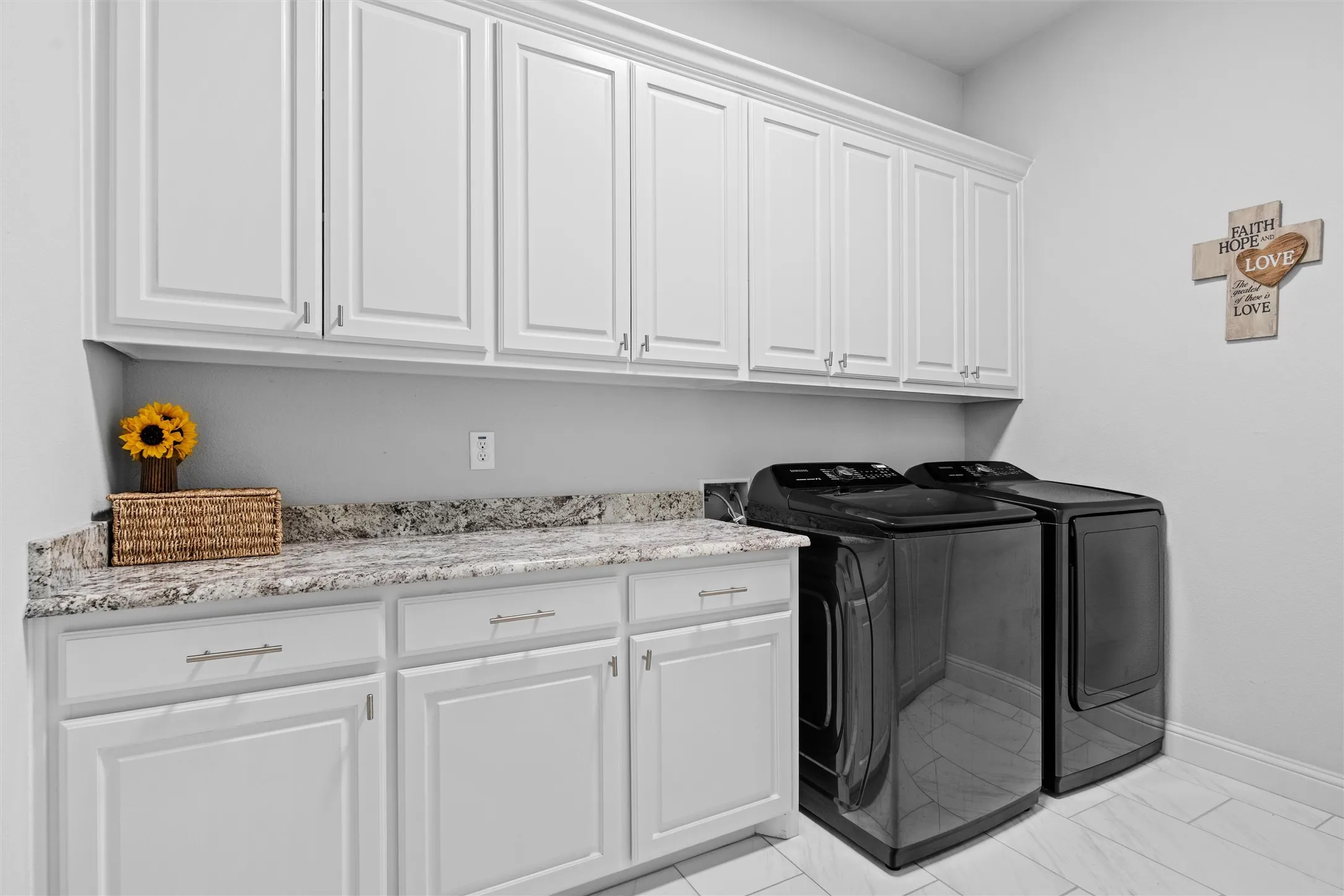 Located by the primary bedroom and mudroom, the utility room has another whole wall of custom cabinets not seen in this photo!