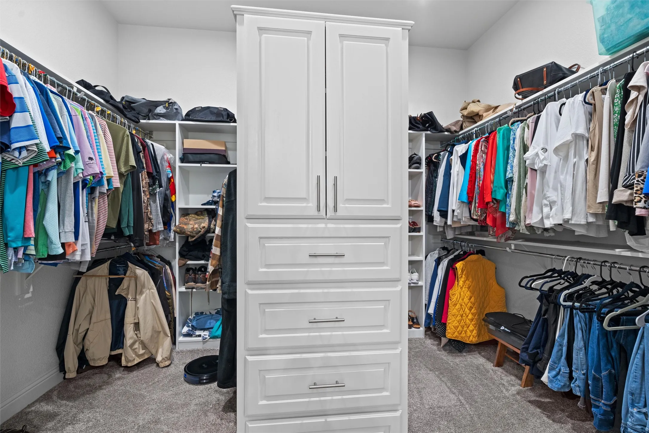 Tons of custom shelving (not pictured) and cabinets, plus plenty of area to hang clothes in this enormous primary closet
