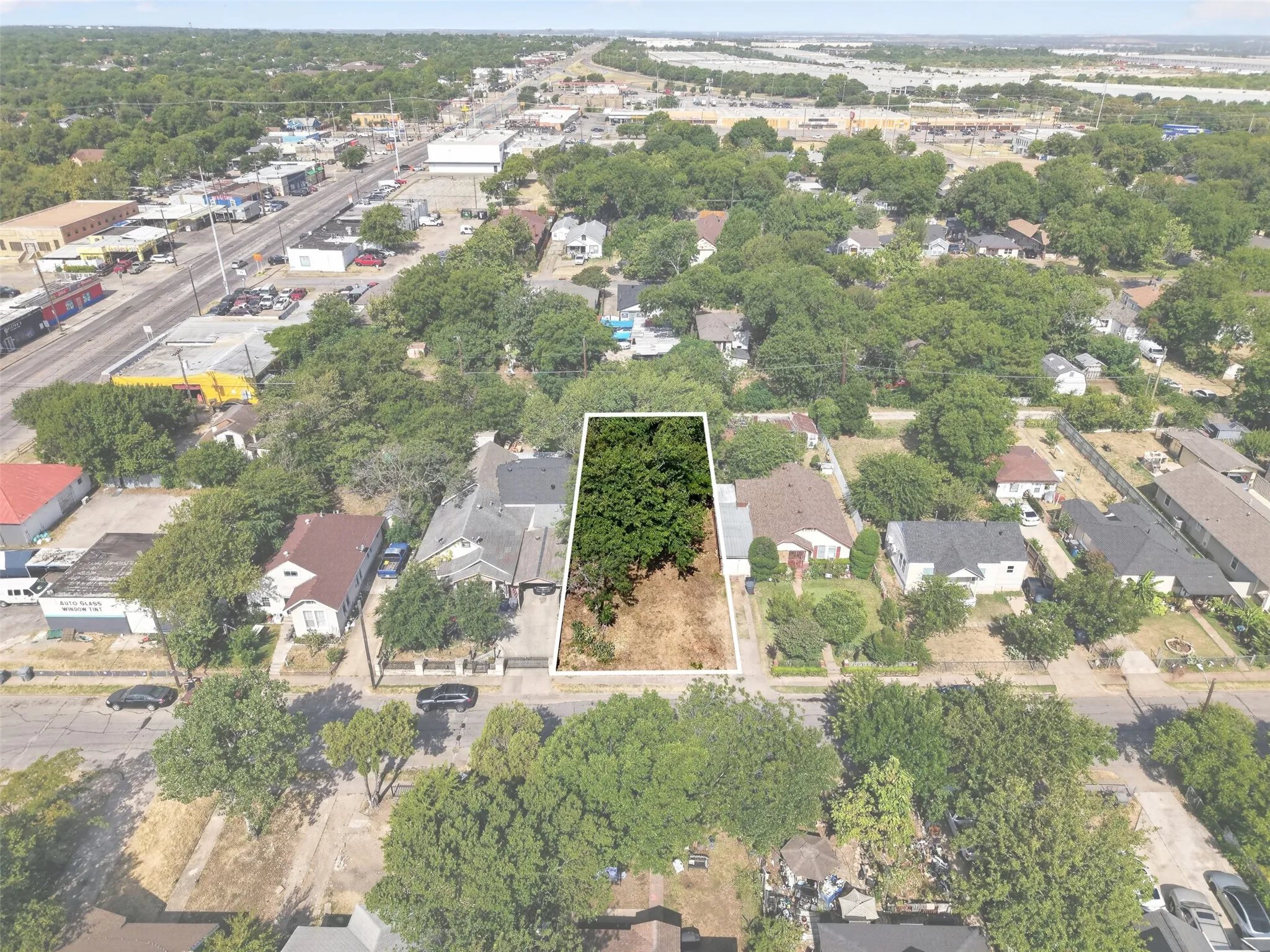 Vacant land parcel featuring mature trees and partial clearing