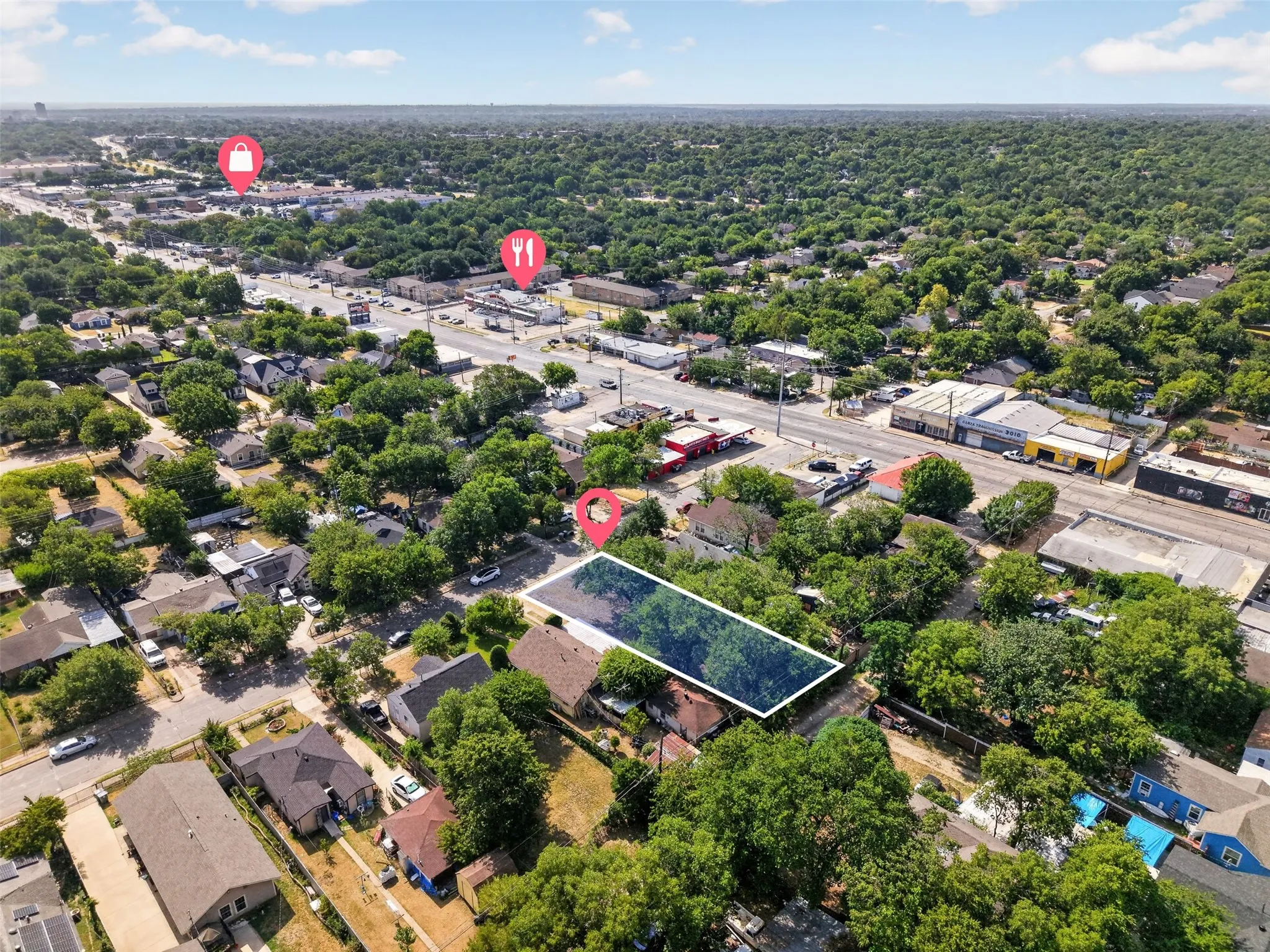 Aerial view showcasing a residential parcel outlined in blue, surrounded by mature trees