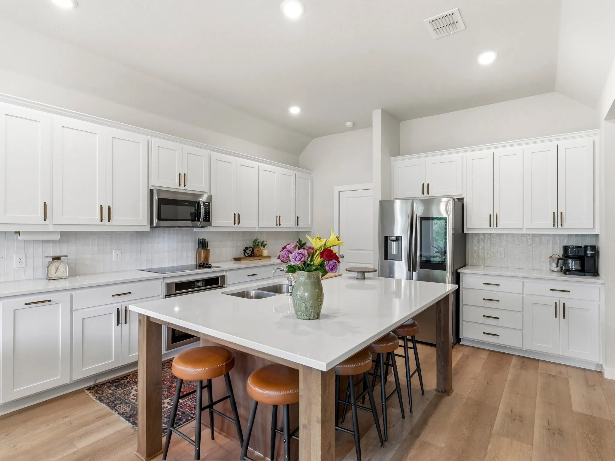 Beautifully appointed kitchen with abundant cabinetry, generous prep space, and an open layout overlooking the main living area.