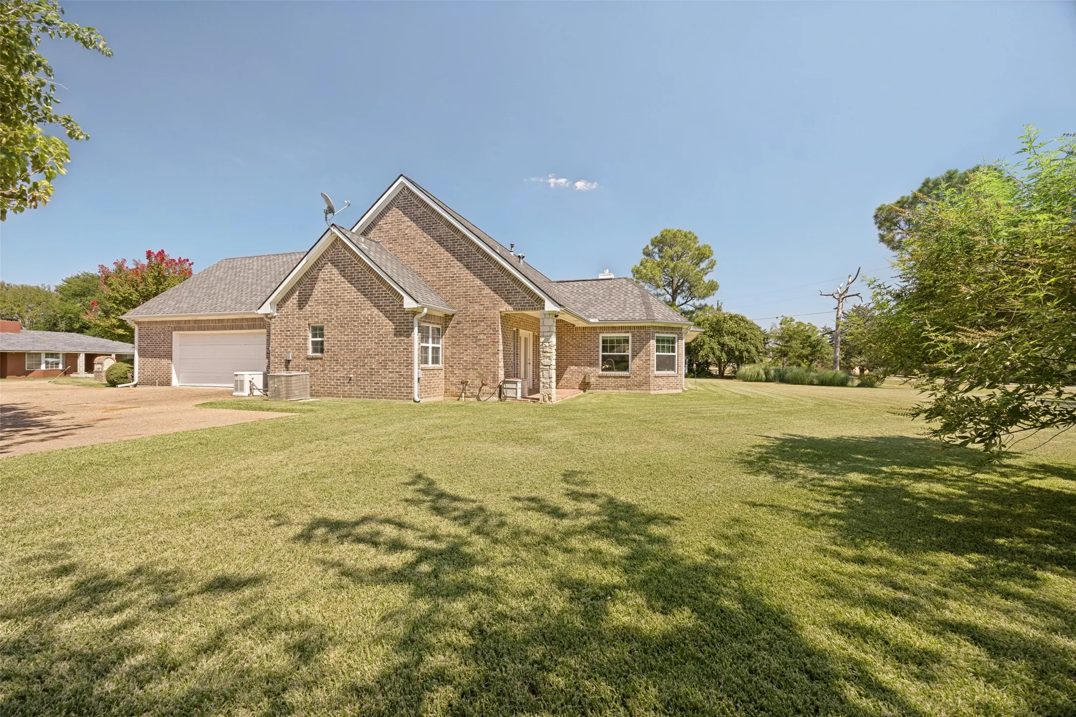 Side view of the home and garage entrance. You can also see the private patio that sits off the second primary suite.