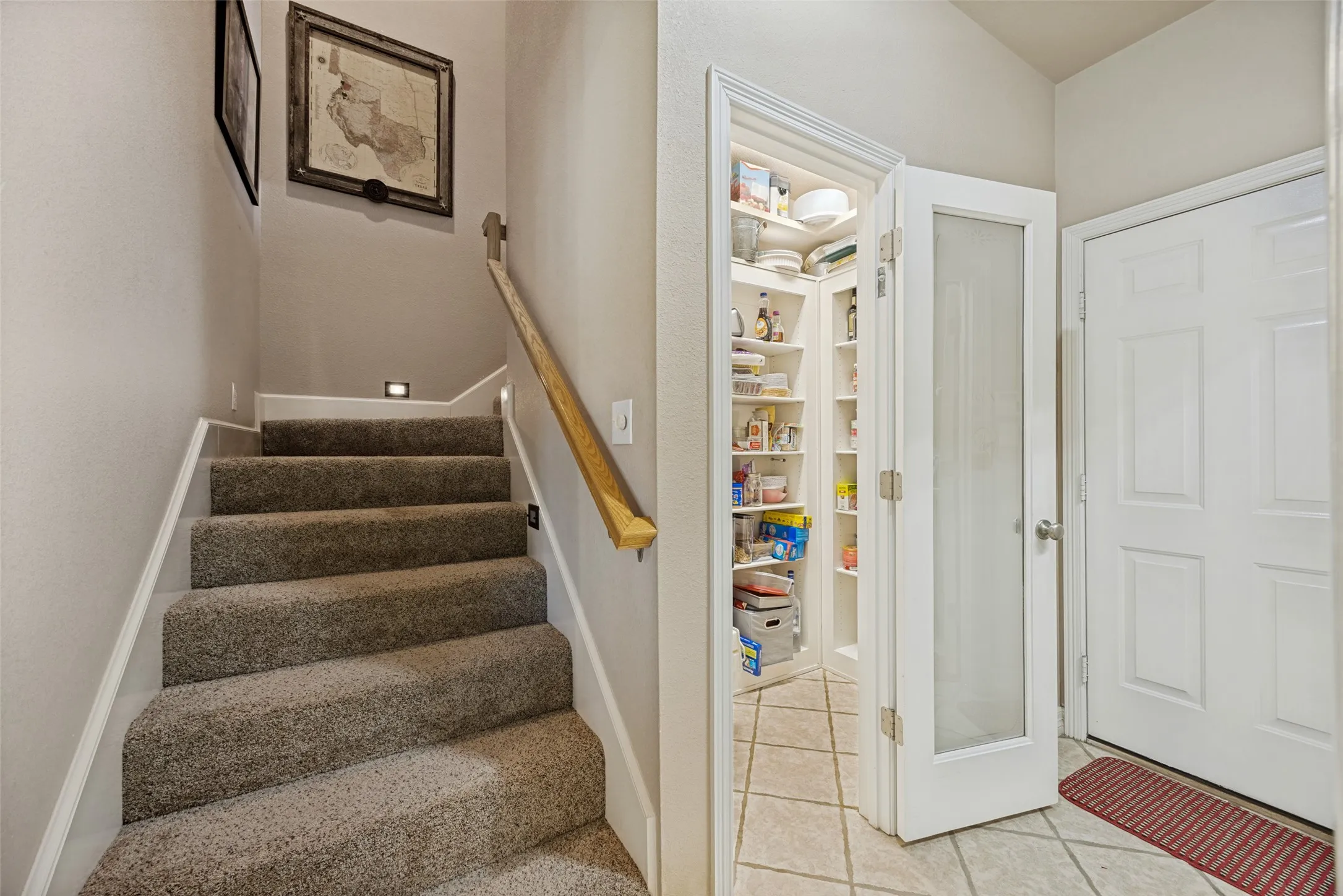 Stairway to the upstairs game room is tucked away between the kitchen and garage entrance.