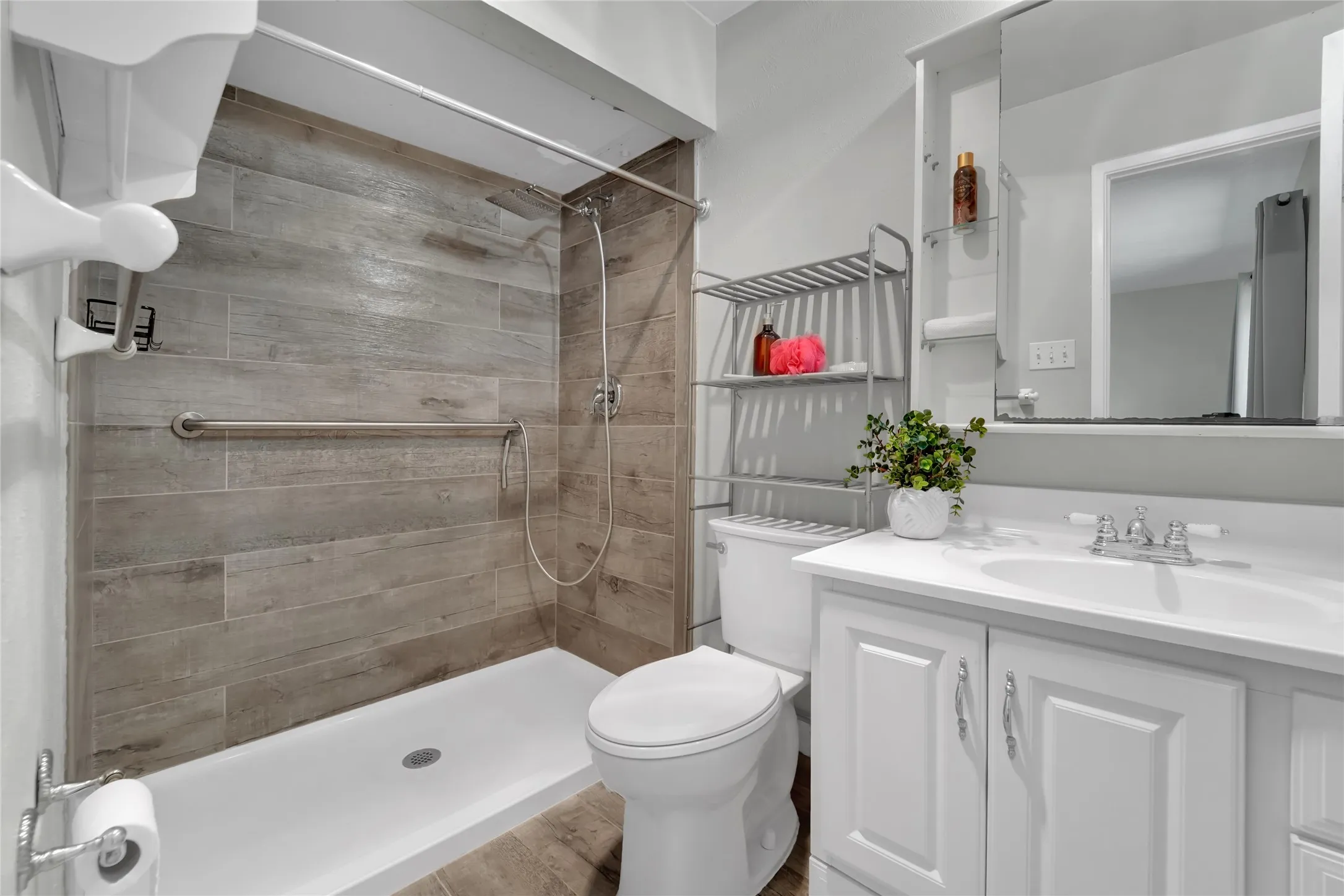 Full bathroom featuring a white vanity with a single basin sink, white cabinetry, and polished chrome fixtures