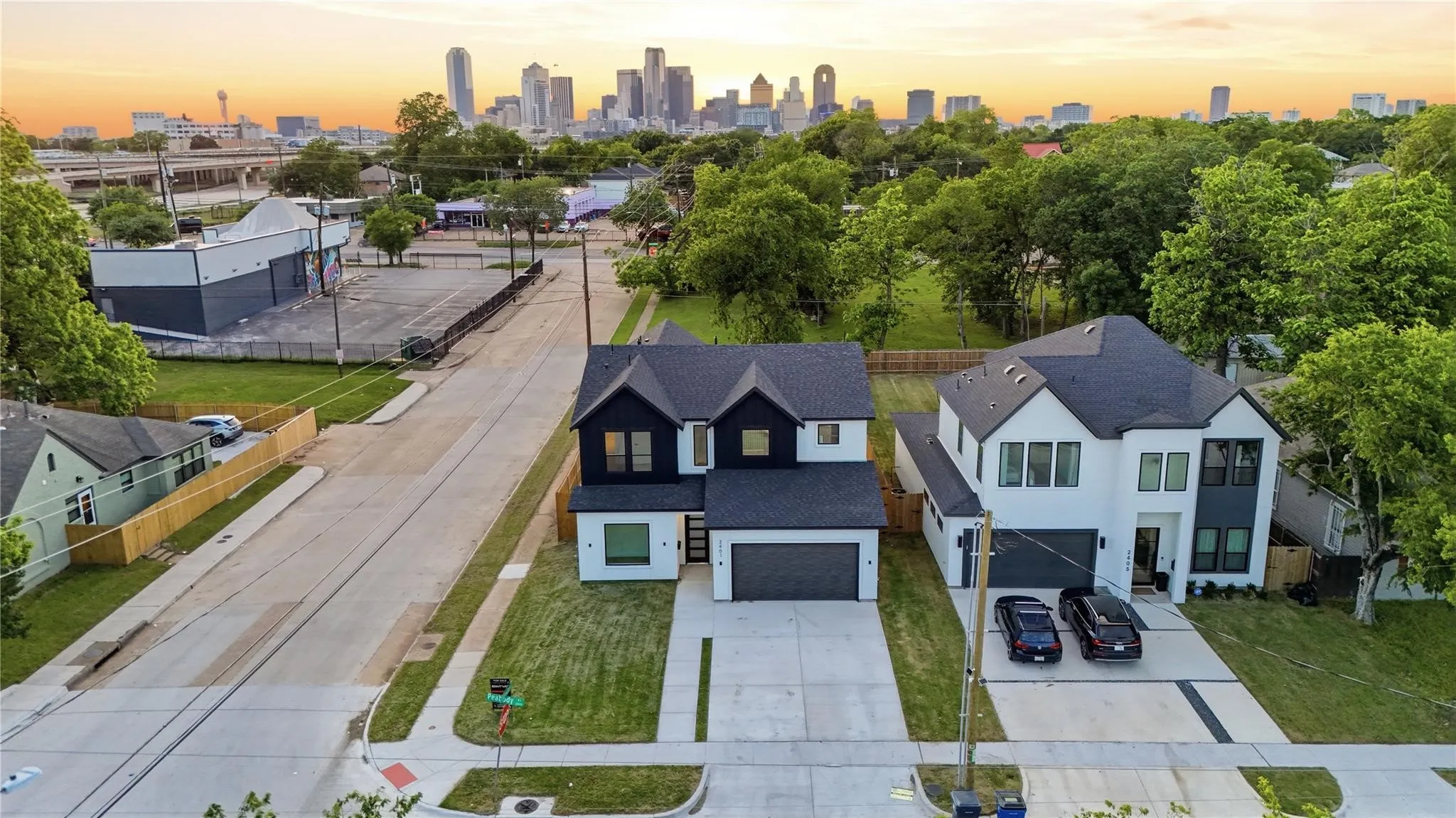 Contemporary two-story residence with a contrasting dark and light facade, featuring a two-car garage, private driveway, and a well-maintained lawn