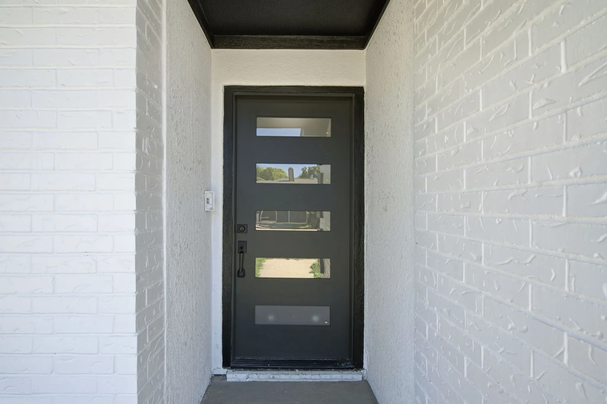 Modern entry door featuring five rectangular lites, a matte black finish, and a coordinating handle set