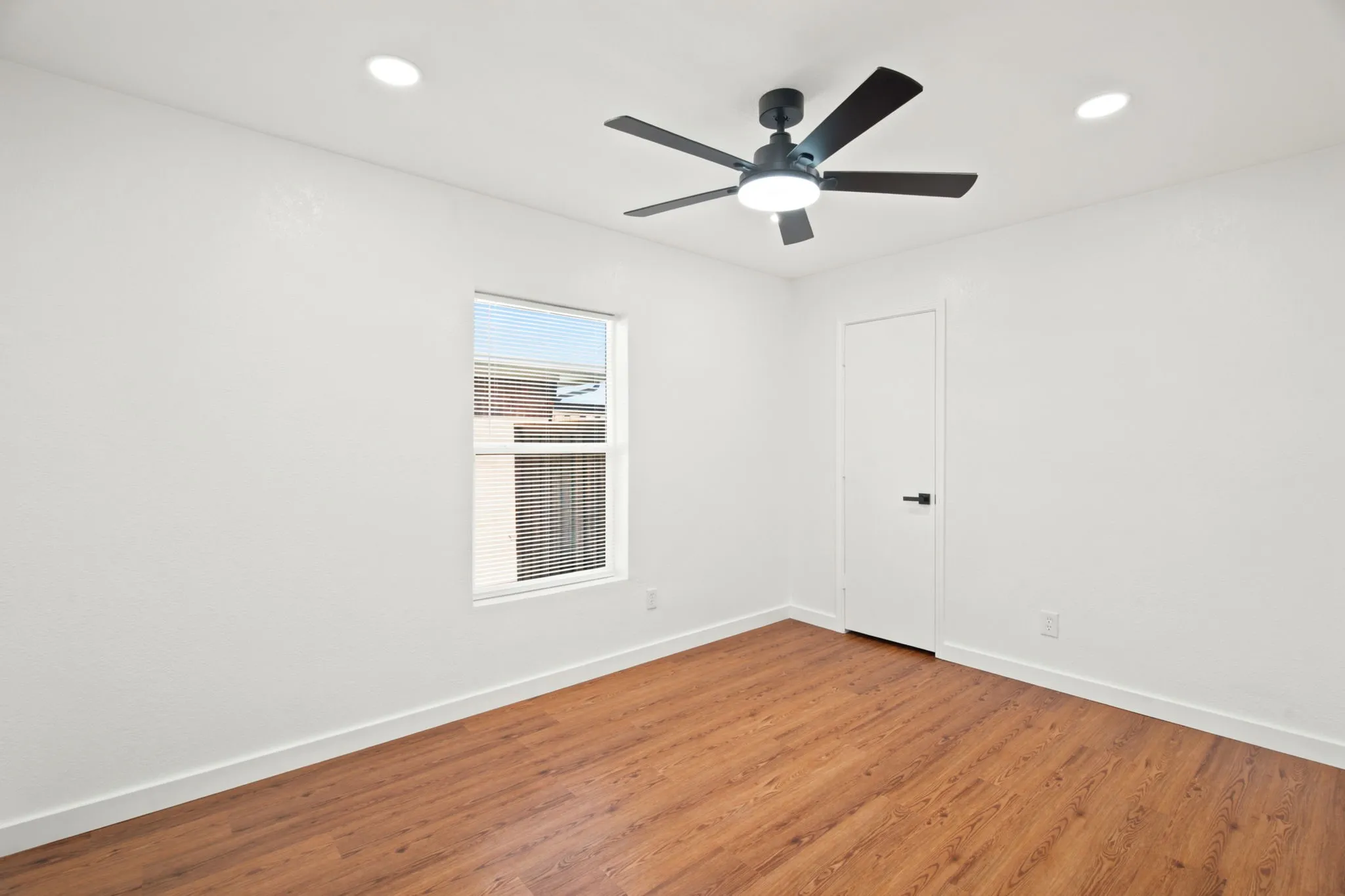 Bedroom featuring wood-finish flooring, a contemporary ceiling fan with integrated lighting, recessed ceiling lights, and a window with blinds