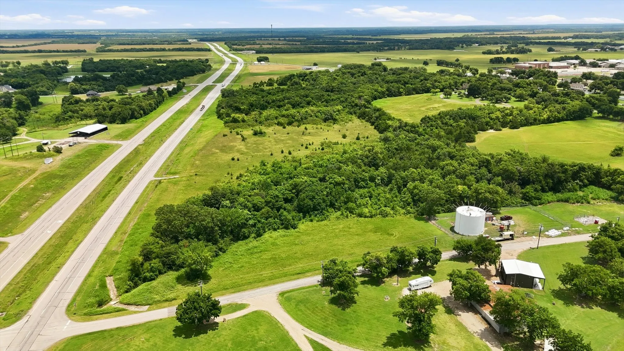 Expansive undeveloped land featuring a combination of open grassy areas and dense tree coverage