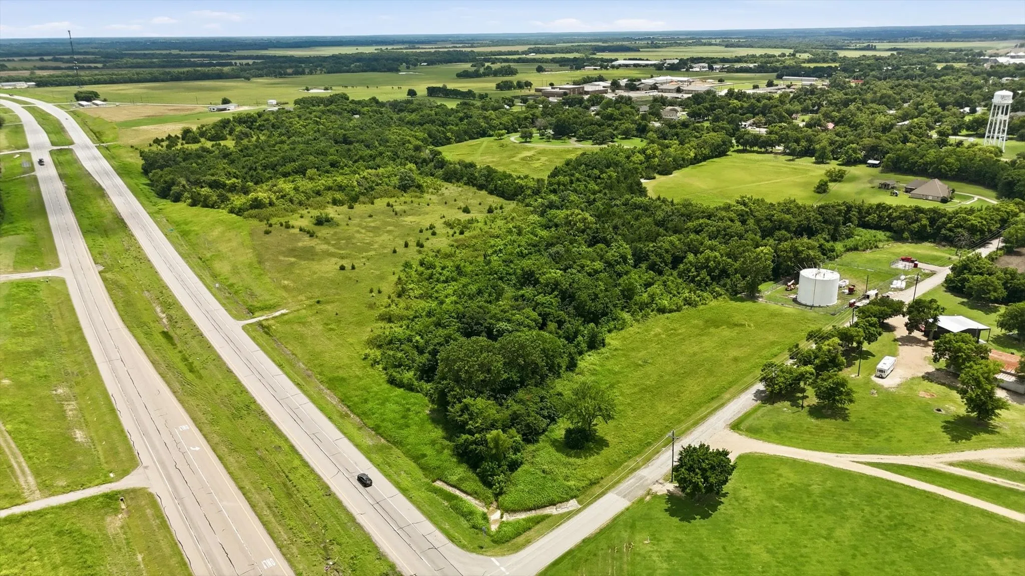 Expansive acreage featuring a mix of open fields and mature tree lines