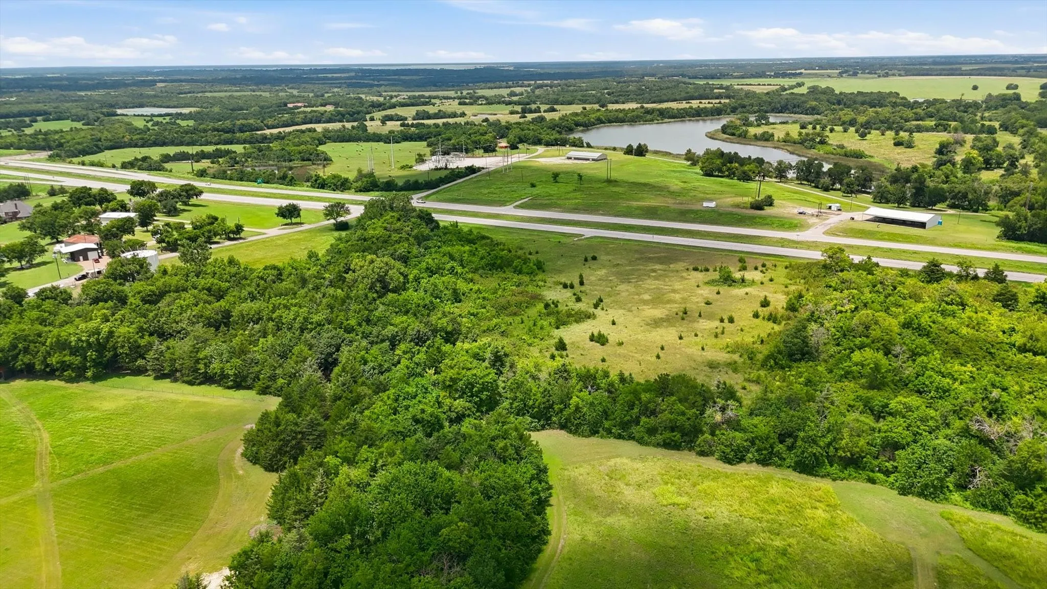 Expansive parcel featuring a mix of open grassy areas and mature tree coverage