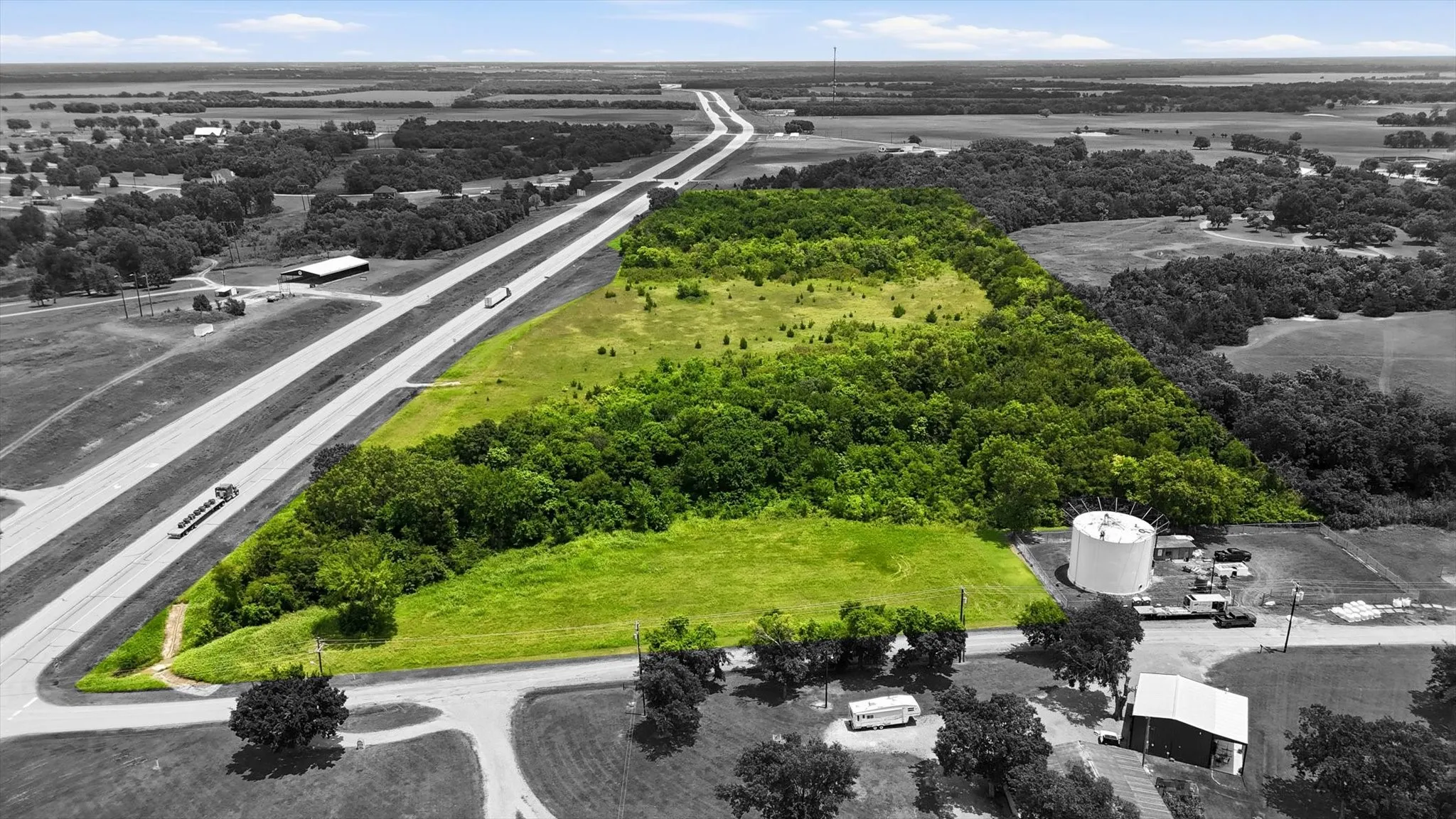 Expansive land parcel featuring a mix of open grass areas and dense tree coverage