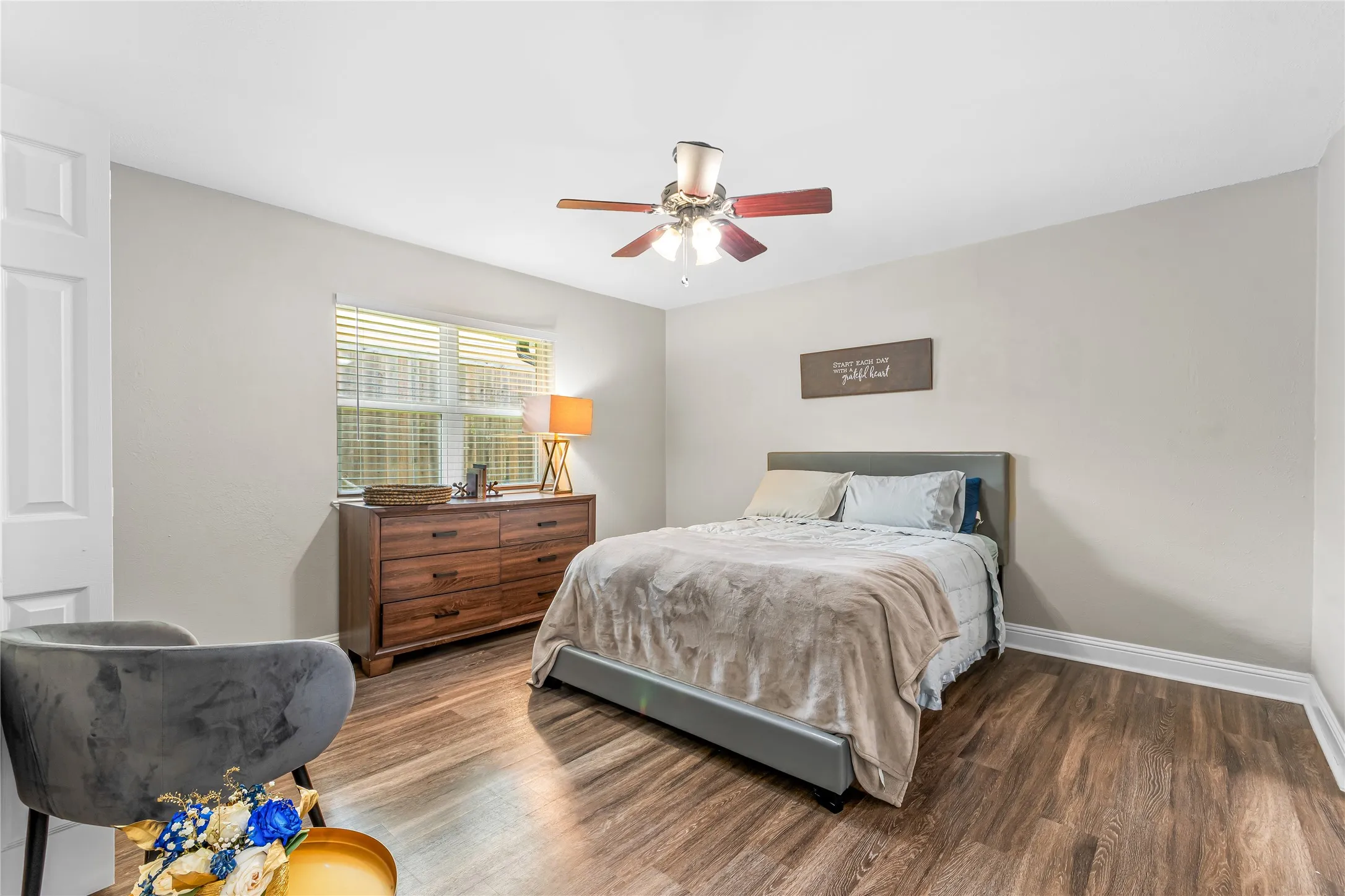 Room featuring woodlike-finish flooring, light grey wall paint, and white trim
