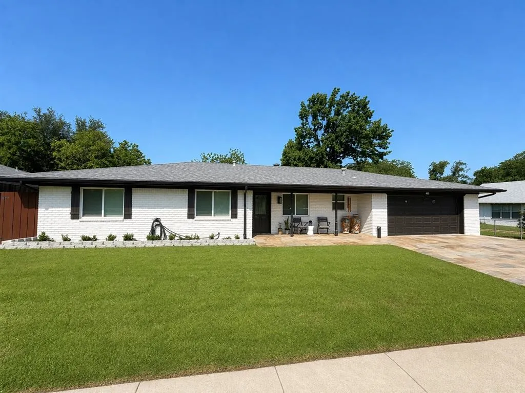 White brick exterior with a dark shingle