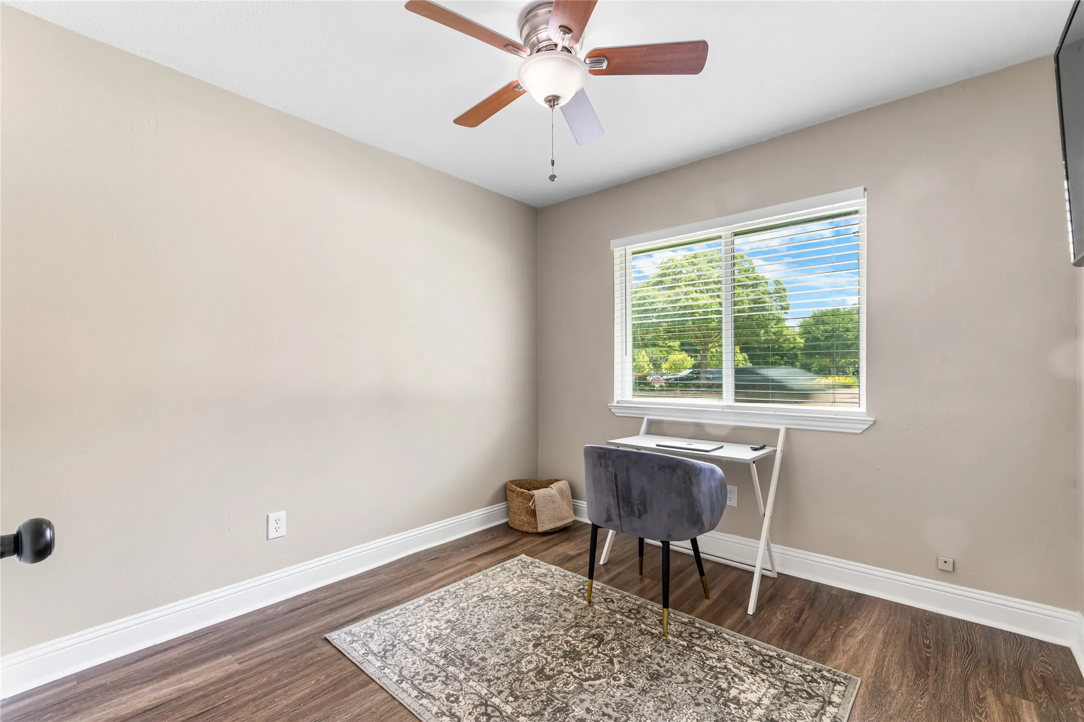 Room featuring wood-finish flooring, neutral wall paint, and white baseboards