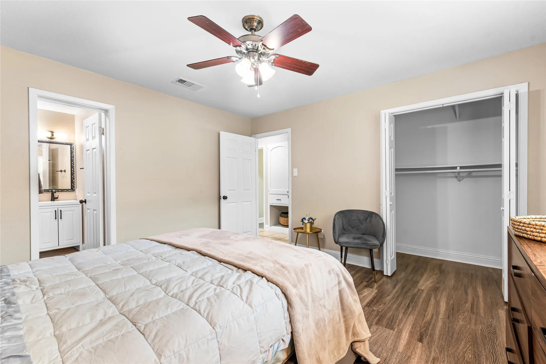 Bedroom featuring woodlike-finish flooring, a ceiling fan with integrated lighting, and neutral wall tones