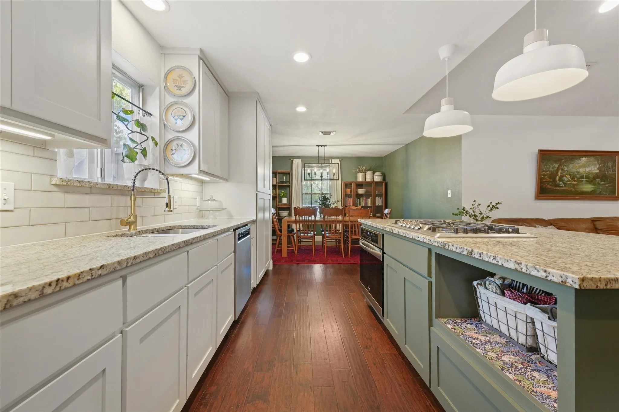 Renovated kitchen featuring granite countertops, shaker-style cabinetry, subway tile backsplash, under-cabinet lighting, stainless steel appliances, and a large center island.