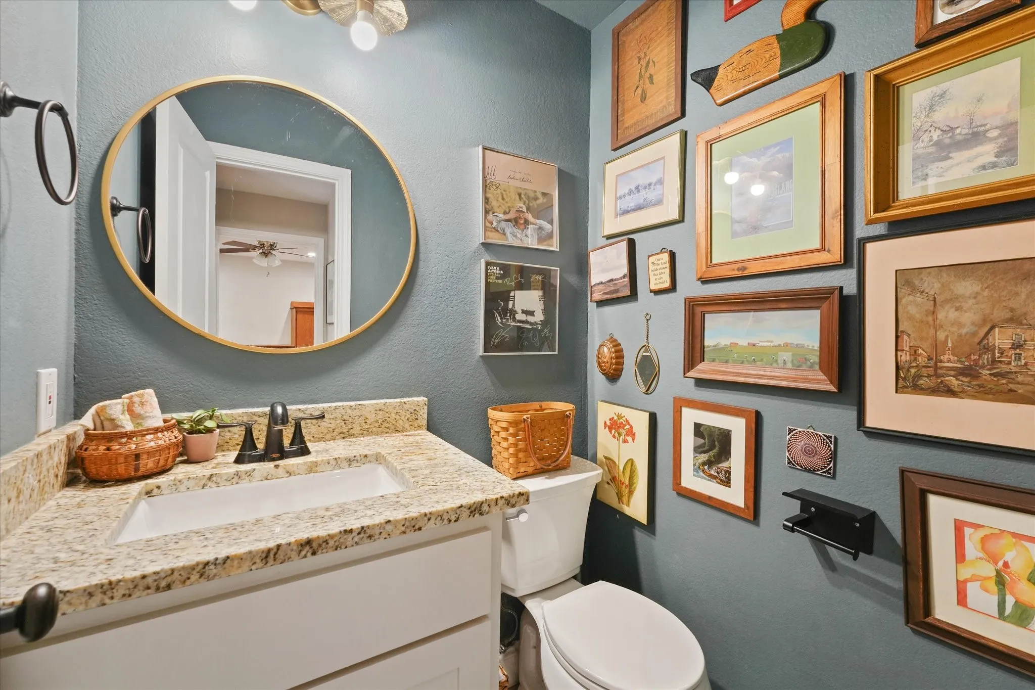 Updated guest half bath with granite countertop, modern vanity, updated fixtures, and stylish accent wall.