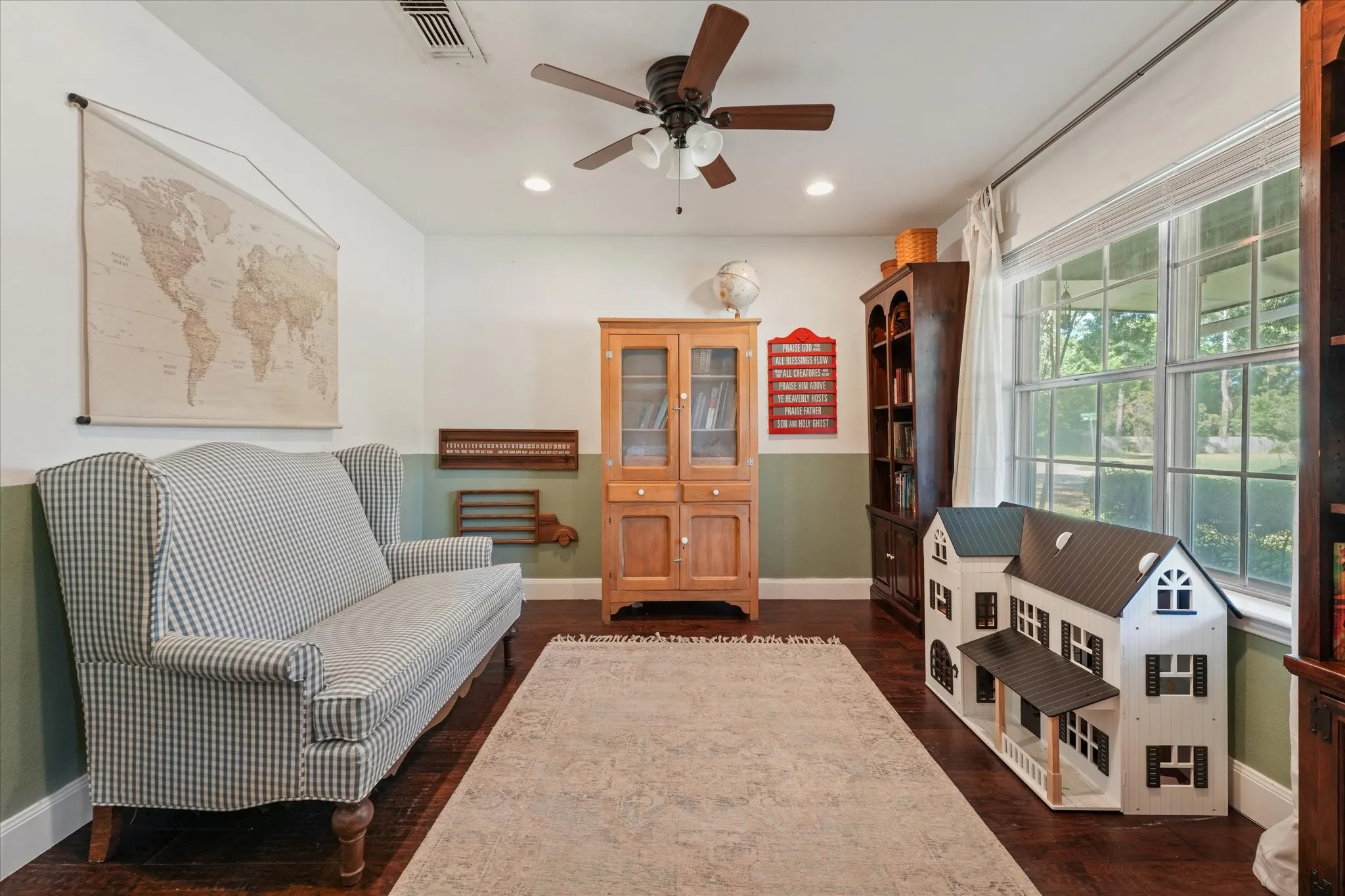 Oversized flex room with hardwood floors, large front-facing windows, and barn doors, ideal for a home office, playroom, library, or second living area.