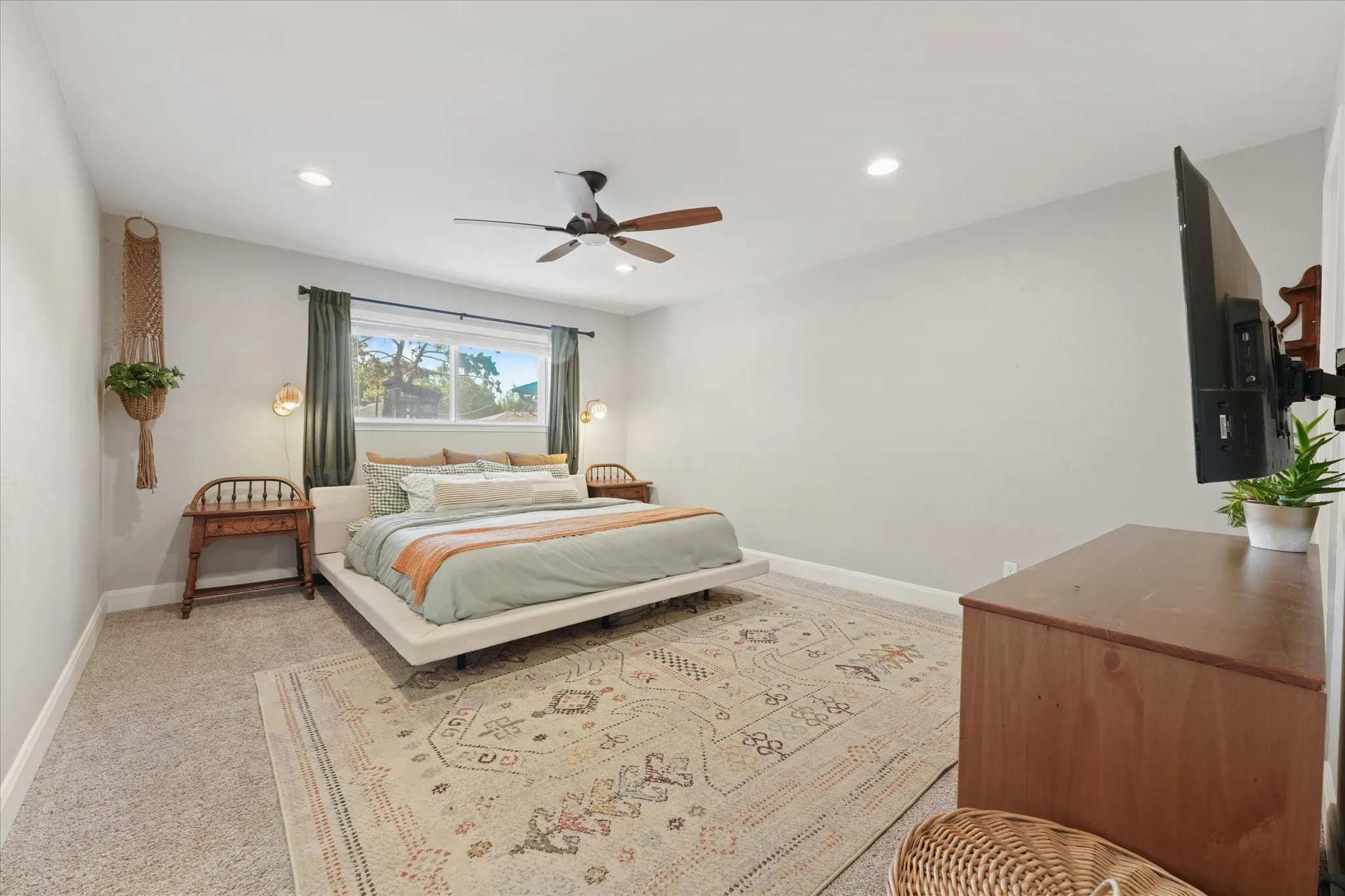 Spacious primary suite with recessed lighting, updated ceiling fan, large picture window, and plenty of room for a king-size bed and additional furniture.