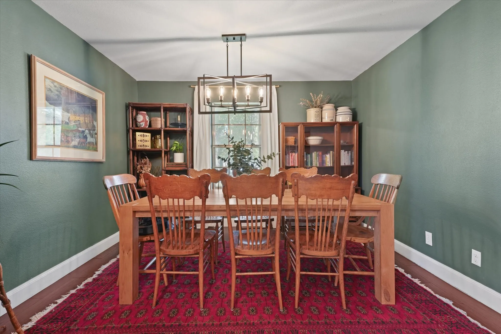 Dedicated dining room with designer lighting, rich accent walls, hardwood floors, and plenty of space for hosting family gatherings and holidays.