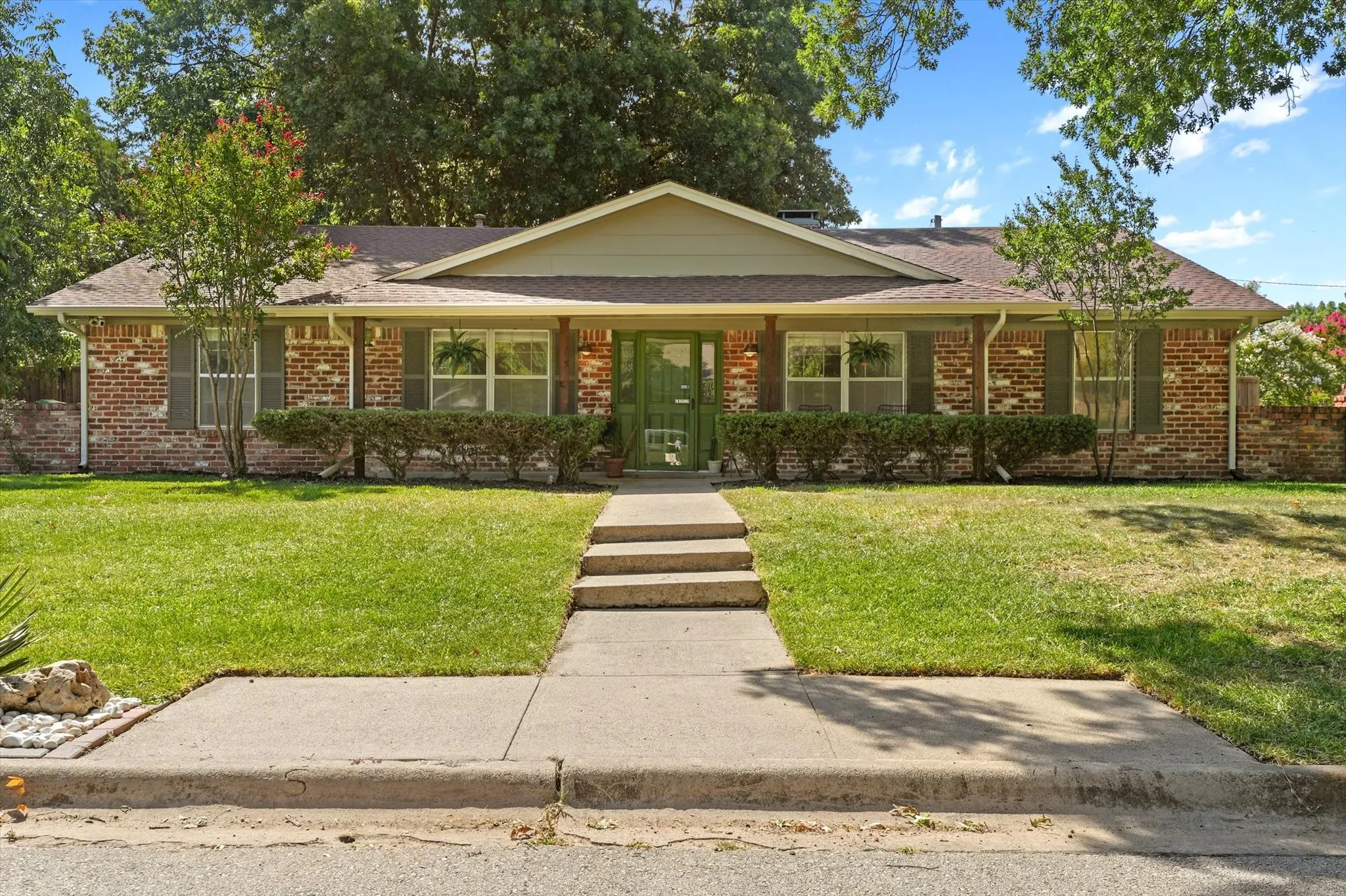 Classic brick exterior with mature landscaping, covered front porch, oversized front yard, and established shade trees in one of Denton's most desirable neighborhoods near Nette Shultz Elementary.