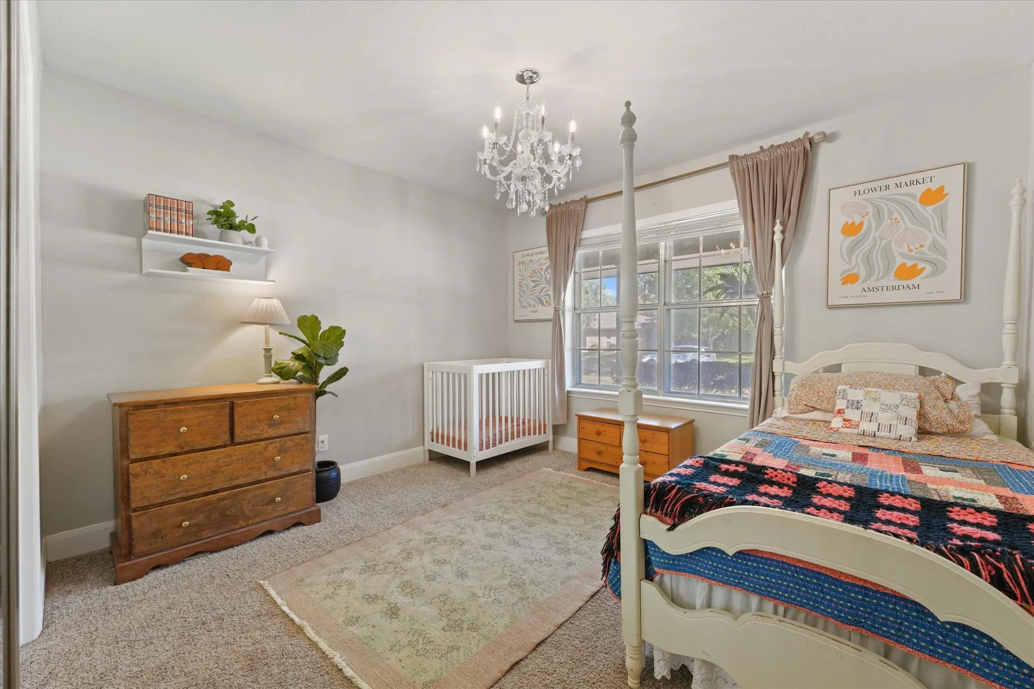 Generously sized secondary bedroom with updated lighting, large windows for natural light, and ample space for a nursery or guest bedroom.