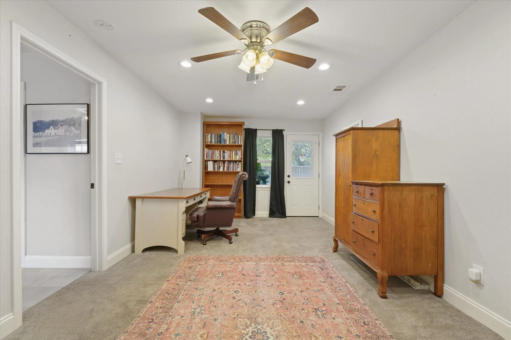 Additional view of the spacious flex room featuring ample space for multiple uses, backyard access, recessed lighting, and room for a home office or guest accommodations.