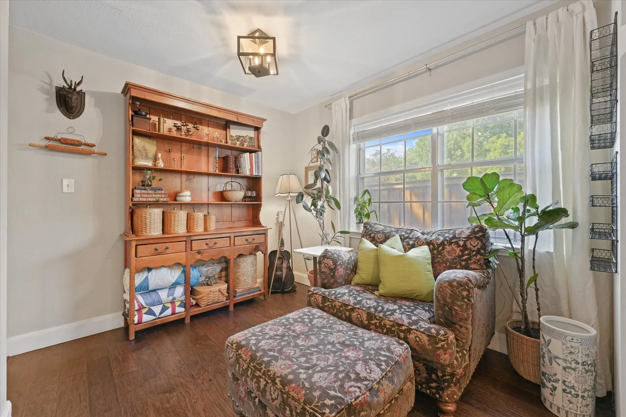 Flexible breakfast nook or sitting area just off the kitchen with abundant natural light, hardwood flooring, and views of the backyard.