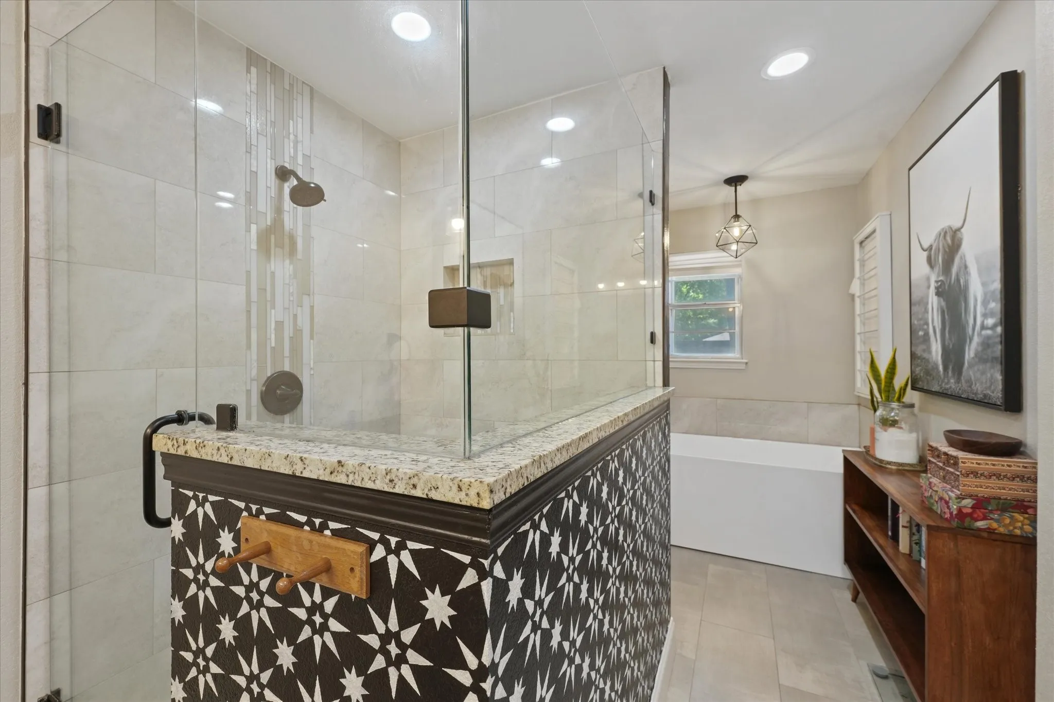 Beautifully renovated primary bathroom with oversized walk-in shower, freestanding soaking tub, dual granite vanities, custom tile, and designer finishes.