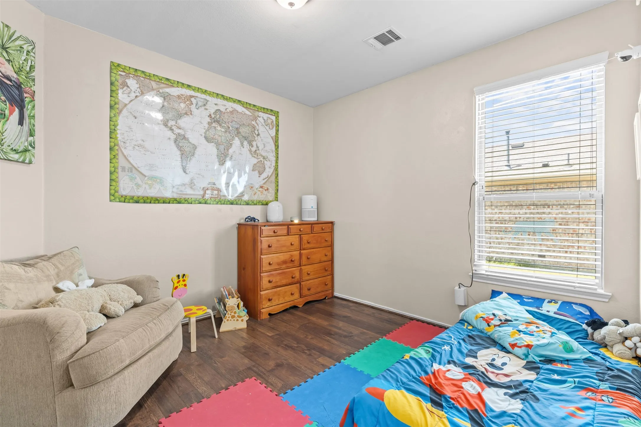 Secondary bedroom with wood flooring