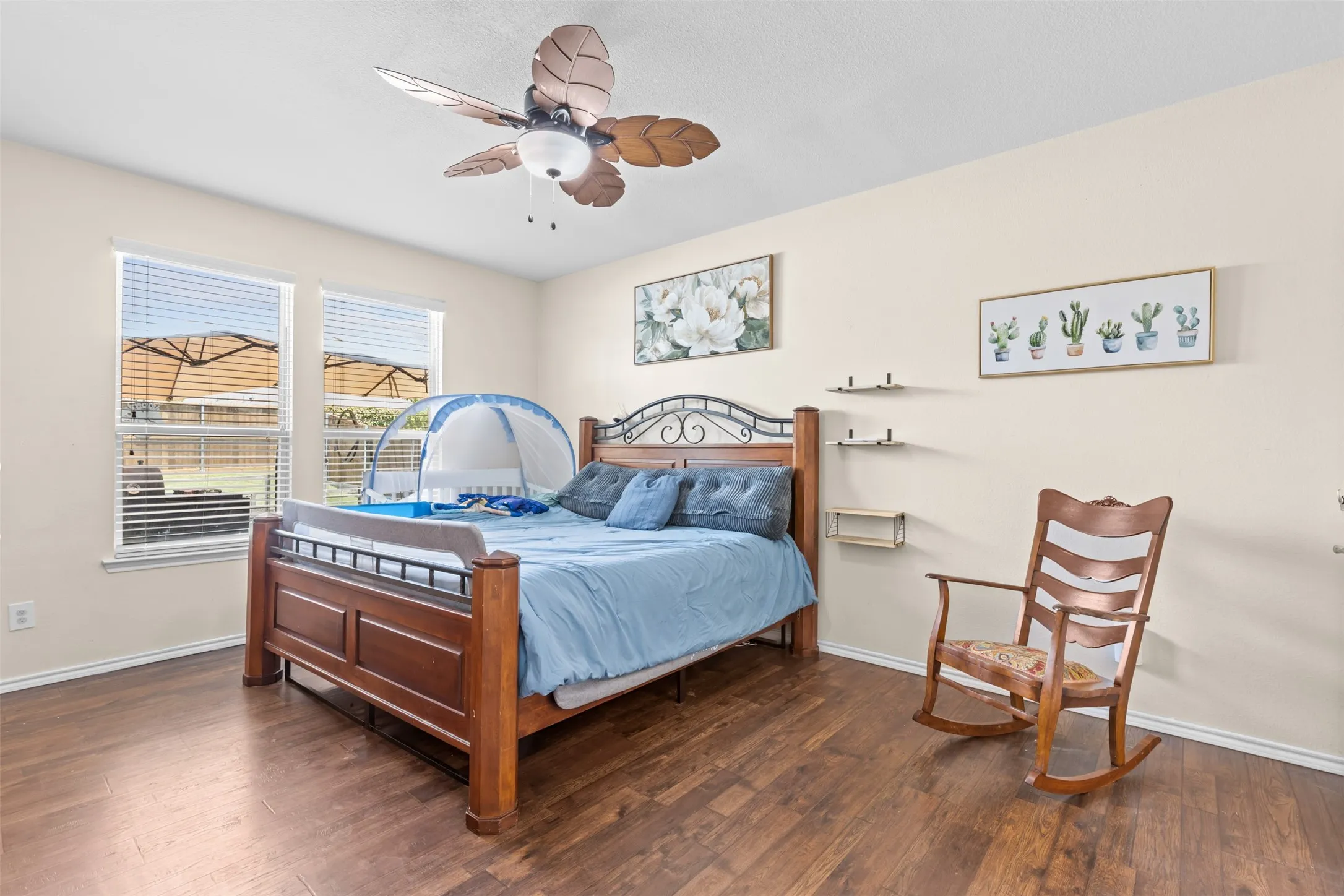 Large primary suite with wood flooring, ceiling fan and lots of natural light