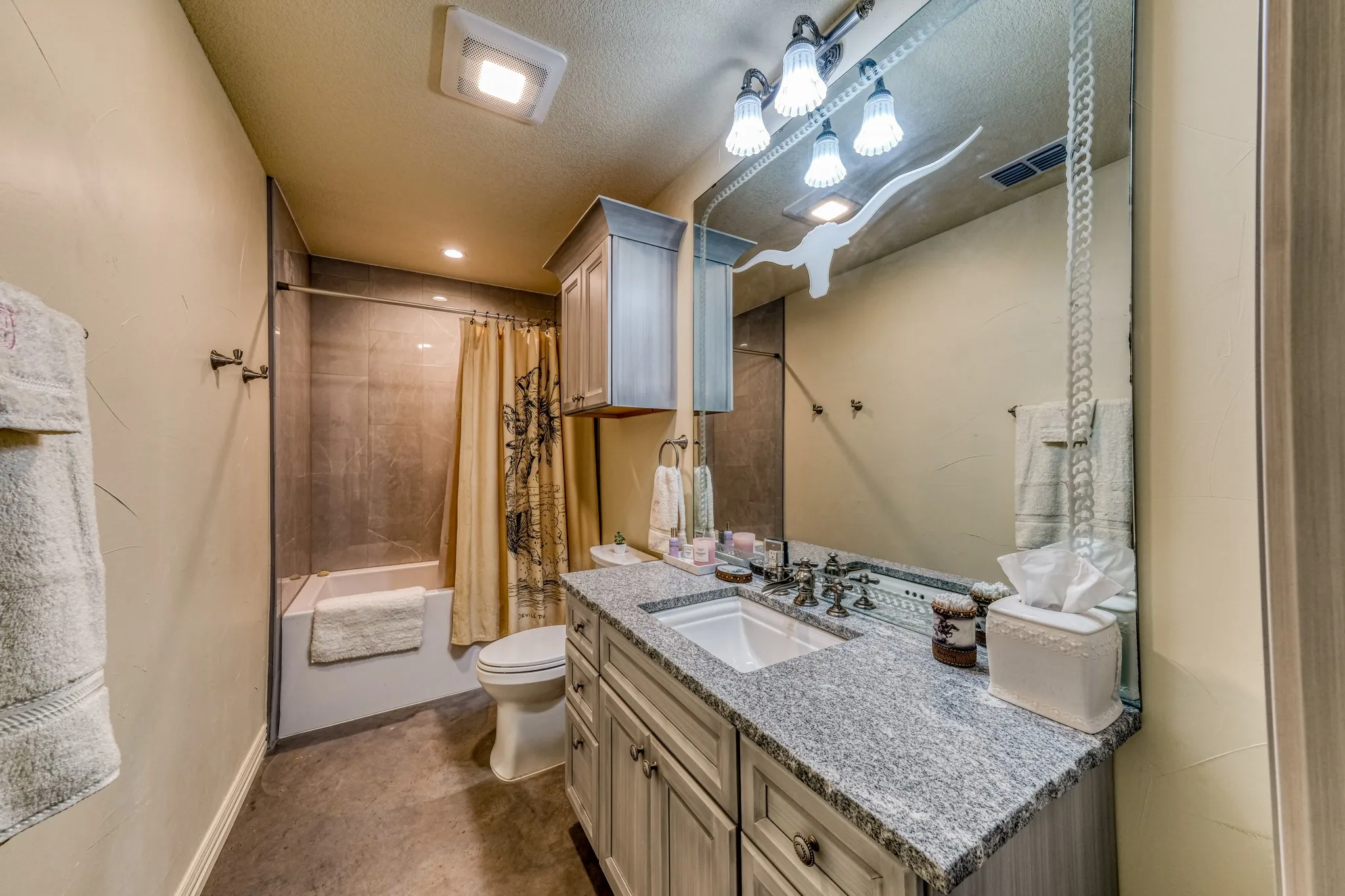 Bathroom featuring a vanity with a light-toned granite countertop, undermount sink, and dark-toned faucet