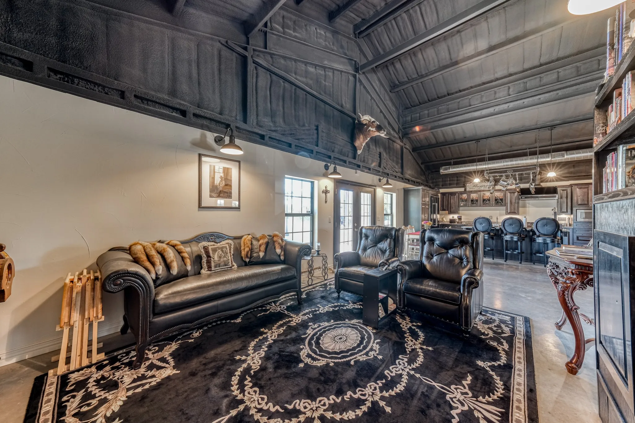 Vaulted wood-paneled ceiling with exposed beams, illuminated by wall-mounted sconces