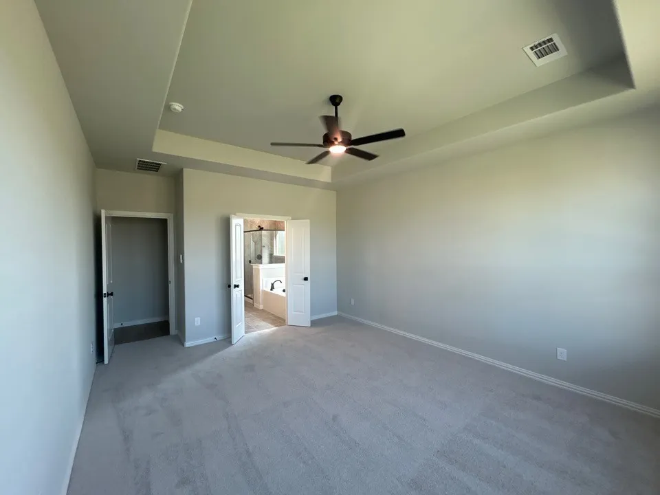 Recessed ceiling detail with a ceiling fan, light gray wall paint, and light gray carpeted flooring