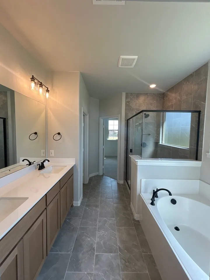 Dual vanity with undermount sinks, wood-finish cabinetry, and matte black fixtures