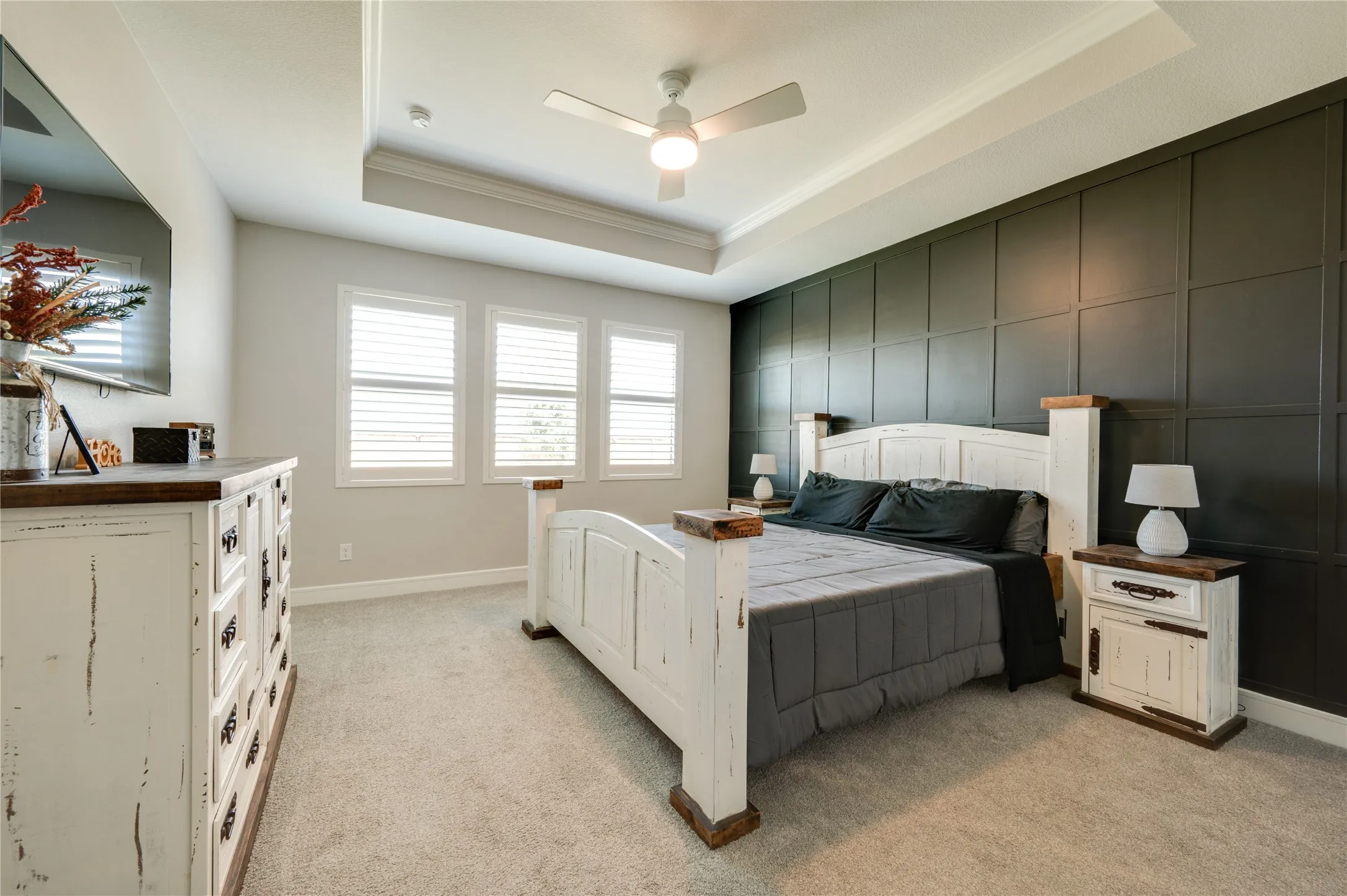 Primary bedroom with paneling wall accents.