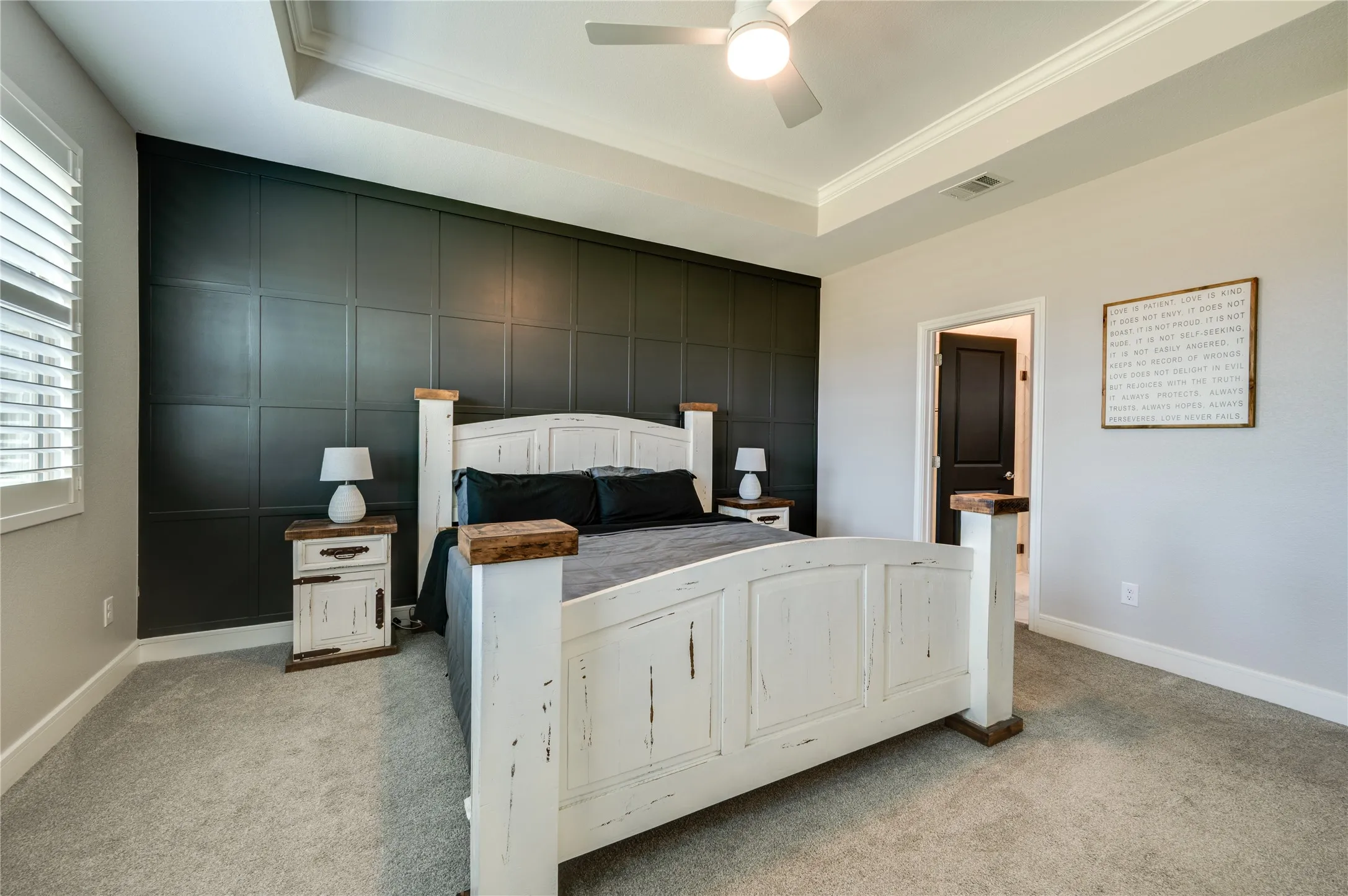 Primary bedroom with paneling wall accents.
