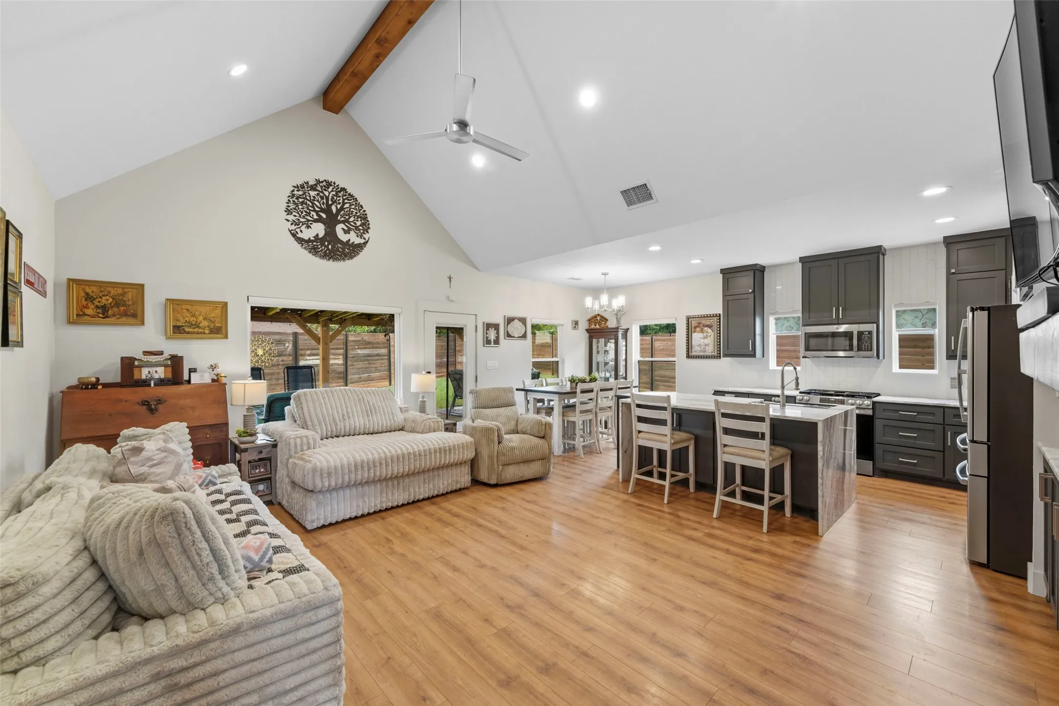 Vaulted ceiling with an exposed wood beam, wood-finish flooring, and an open-concept layout